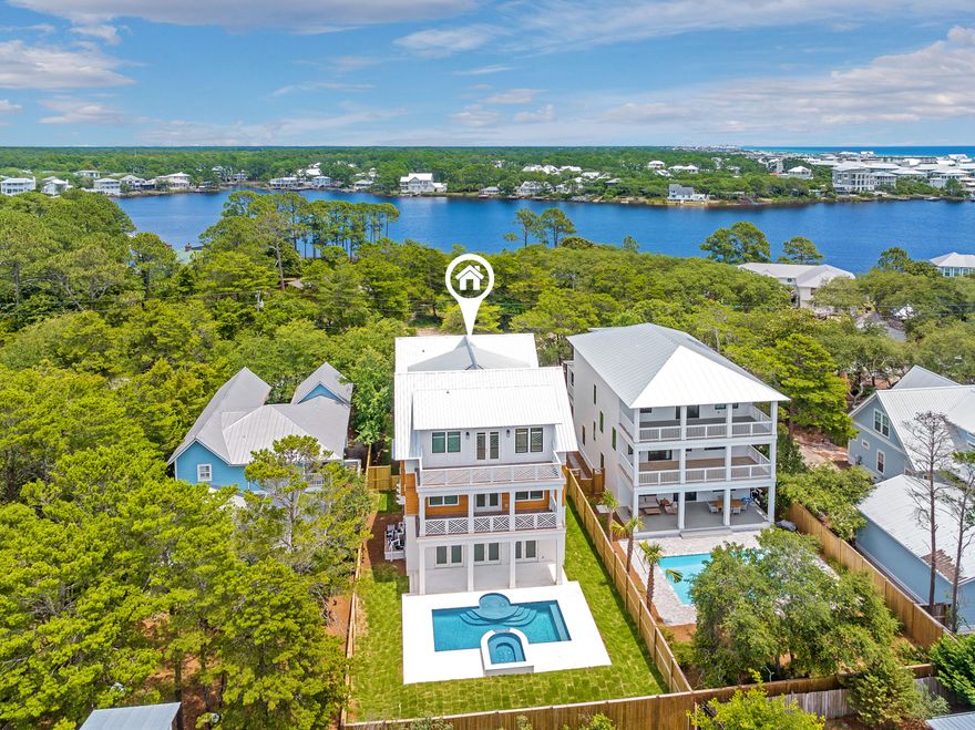 Stunning new construction home perfectly positioned in a prime Seagrove location within close proximity to large public beach access. Enjoy the spacious lot with a plethora of pavered parking, green space, large backyard with pool/hot tub combo, all with no HOA dues. This luxurious beach estate is the perfect combination of laid back living and upscale sophistication. The entry of the home greets you with a tiled front porch leading to the gorgeous arched mahogany front doors. The main level was designed for entertaining with its high ceilings and large open floor plan that includes the living room, kitchen, and dining area. Large doors blend this space seamlessly to the outdoor pool deck where you will find a very accommodating pool plus an integrated hot tub with waterfall feature. The living room space is adorned with a gas fireplace, wet bar with 2 wine/beverage refrigerators, shiplapped walls and white coffered 12' ceilings. The well appointed kitchen comes complete with a Thermador appliance package, beautiful tile backsplash wall that runs to the ceiling, marble counters with gold accents, and a hidden walk-in pantry! White oak flooring and shiplapped walls round off the coastal feel and run throughout the home. Perhaps one of the best features of the main level is 2 garages! You will also find a 1/2 bath and 3 stop elevator on the first floor for added convenience. The second floor has a large master suite with private porch, huge walk-in closet, and grand master bath. Adjacent to the stairs you will find a large flex space, offering a multitude of opportunities. This space also has a 1/2 bath beside it making it great for a bunk room conversion or living area. The east end of the second level contains 2 guest bedrooms, both with ensuite baths. There's also a very spacious laundry room on this level. The 3rd floor is a similar reflection of the 2nd. It consists of another primary suite with private porch. There's also additional laundry hookups in the primary closet. The flex space on this level is also filled with opportunity to transform into a bunk area, game room, office, or living room. The east end of this floor has 2 guest rooms and a shared bath. All closets throughout the home have wood built-ins. The home was constructed with extreme attention to detail and high-quality finishes, including Ipe wood decking. Enjoy prime Seagrove living with the Eastern Lake public beach access being just under 900 feet away where the county has assembled over 6 acres of beach. This beach access also allows for access to Eastern Lake and its outfall to the gulf, making it a very unique experience. Seagrove is centrally located along 30A with close proximity to Seaside, restaurants, shops, and all that the 30A has to offer.
