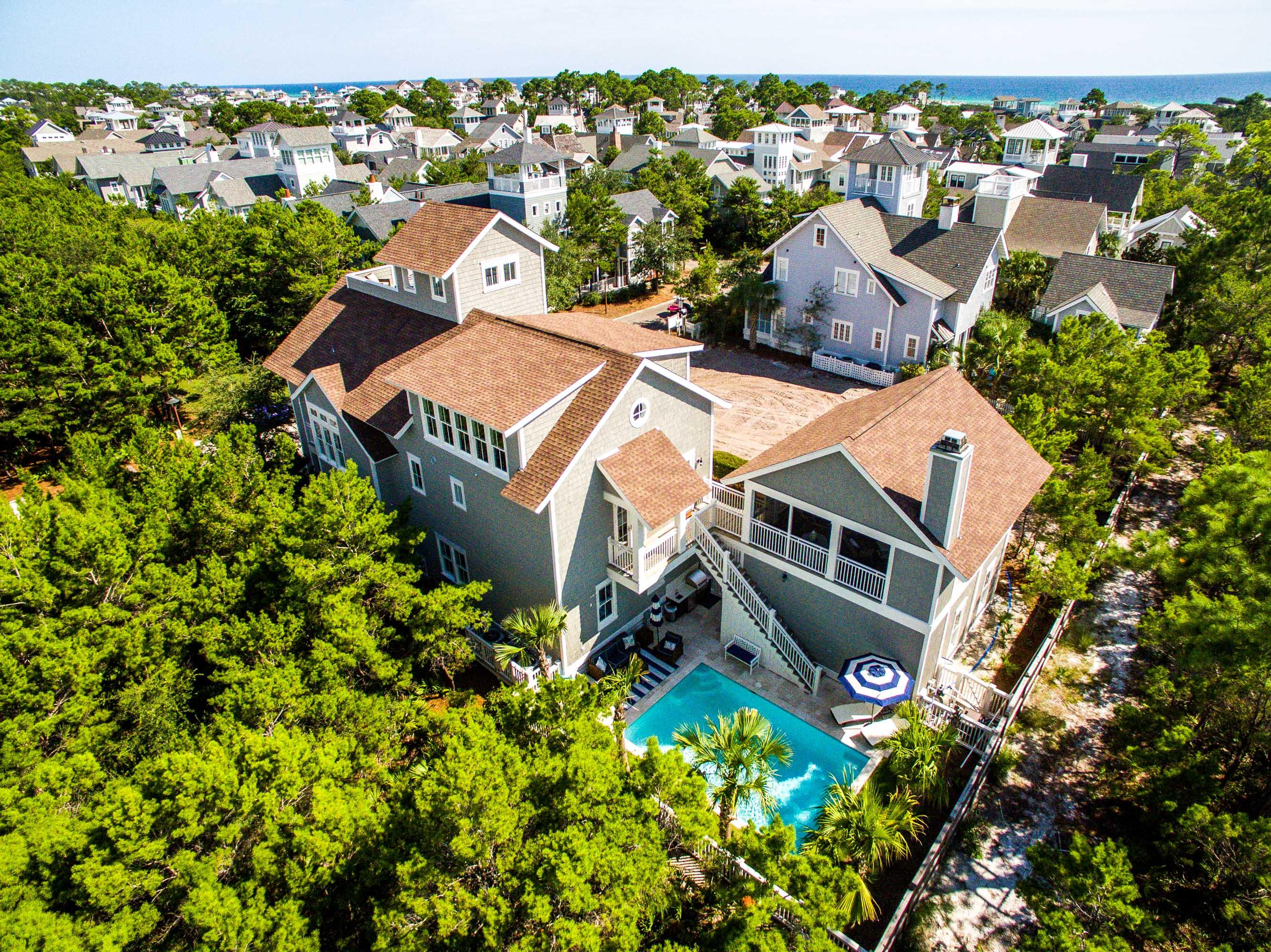 This custom designed residence inWaterSoundBeach is sure to impress. Located on an oversized homesite that backs up to the conservation area of Deer Lake State Park & fronts Puttering Park there is a tremendous amount of privacy. The impressive outside retreat is complete with an enormous heated pool, summer kitchen & plenty of room for entertaining.The interior selections are a refined sophistication evident throughout the property.One immediately appreciates the skillful millwork in the walls, trim, pecky cypress doors & cabinetry.There is a spacious master ensuite on the first floor & three additional guest bedrooms with ensuites that all exude a perfect beach vibe with a calming coastal palette.A sand room & laundry complete this level. Head upstairs & find the open kitchen, dining & living areas complete with pecky cypress ceilings. The gourmet kitchen does not disappoint with all of the highest end accoutrements including Thermador appliances & large breakfast island. There is an abundance of natural light streaming through the windows & doors off the covered porch which is spacious enough for both eating & relaxing. A second master suite & powder bath are also on the second floor. A wet bar including wine refrigerator, sink, ice maker & double drawer dishwasher service one of the most creative & useful outdoor living spaces in the community. This screened gathering spot is the perfect place to sit & unwind, enjoy the custom outdoor fireplace or play a game of ping-pong. Head upstairs to the third level to watch a movie, play a game of pool or indoor shuffle board & much more. Another guest bedroom with two queen beds & full bathroom complete the third story. On the top floor is the impressive tower where the oversized deck allows everyone to enjoy the Gulf of Mexico views. Other special features of this home include carrara marble, glass tile, dumb waiter, built-in speakers throughout & two car garage. This spectacular beach compound exudes a relaxed ambience which is unique & refreshing!