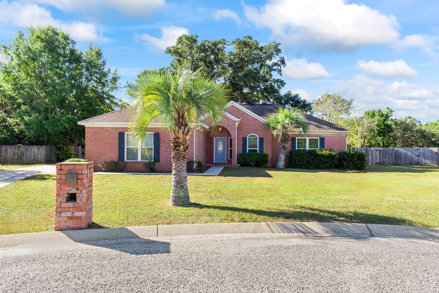 Welcome to your peaceful retreat in the heart of Navarre! This beautiful home sits on a spacious corner lot with a charming circle drive for added privacy and a side-entry garage with extended driveway. Step inside to soaring tall and vaulted ceilings and a large open floor plan perfect for entertaining or relaxing in comfort. The living area features a cozy fireplace accented with backsplash tile and opens through French doors to a beautifully shaded, fenced backyard filled with mature trees and palm accents your own tranquil outdoor haven. A formal dining room with a neutral gray palette and vaulted ceilings creates an elegant space for gatherings. The kitchen boasts stainless steel KitchenAid appliances, stylish gray repainted cabinets, a bay window overlooking the backyard, double double sink, pantry, gorgeous gray-and-white drop lighting, and tiled flooring that complements the home's fresh, airy design.
Enjoy tile flooring in the entry and laundry hall, two linen closets for extra storage, and tile flooring in the full bath. The large master suite impresses with tray vaulted ceilings, double windows for natural light, and a bath featuring a Corian-look vanity, walk-in tub, and separate shower. Additional bedrooms are nicely sized and well-appointed. With no HOA and minimal restrictions, you'll love the freedom and quiet, low-traffic street setting. Located just minutes from shops, restaurants, and Navarre's stunning beaches, this home blends comfort, privacy, and coastal convenience beautifully. A rare findspacious, serene, and move-in ready!