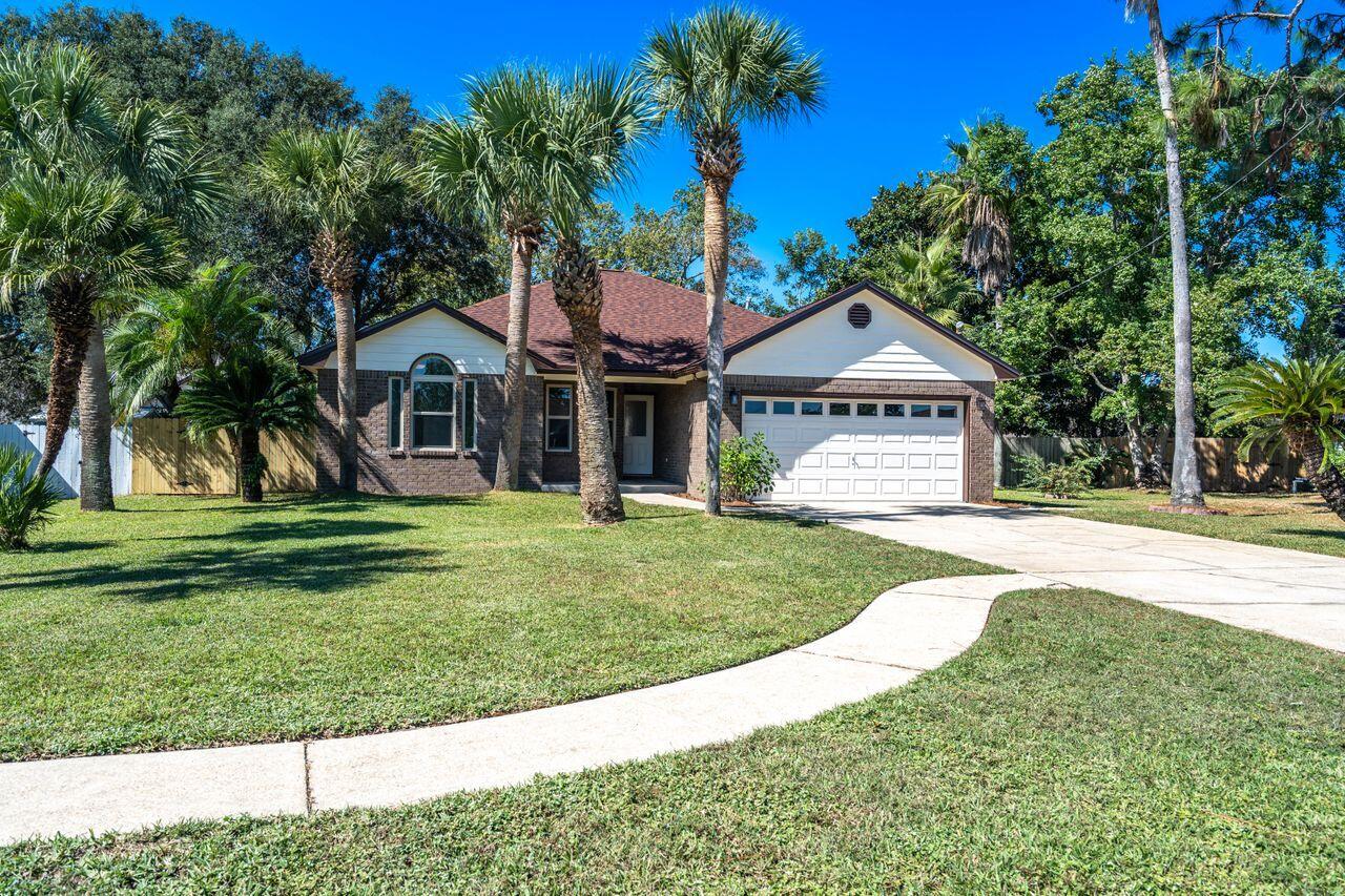 Honey, STOP THE CAR! We've found it! Freshly painted and looking for the perfect family to call this ''Little Gem,'' home. Lush St. Augustine grass under foot just feels like Florida. Manicured palm trees remind you of a little slice of Paradise just minutes from the sugar white sands of Navarre Beach. With a large back yard, anything is possible: BBQ's, family gatherings, or playing catch with the kids . The kitchen is appointed with rich wood cabinetry, new leather textured granite counters, and large stainless sink. Lliving room amenities include wood burning fireplace, built-in bookcase, and vaulted ceiling. Vaulted ceilings are, also, found in the master bedroom, while double vanities and a shower/tub combo are found in the master bathroom. Roof is NEW and windows are impact rated.