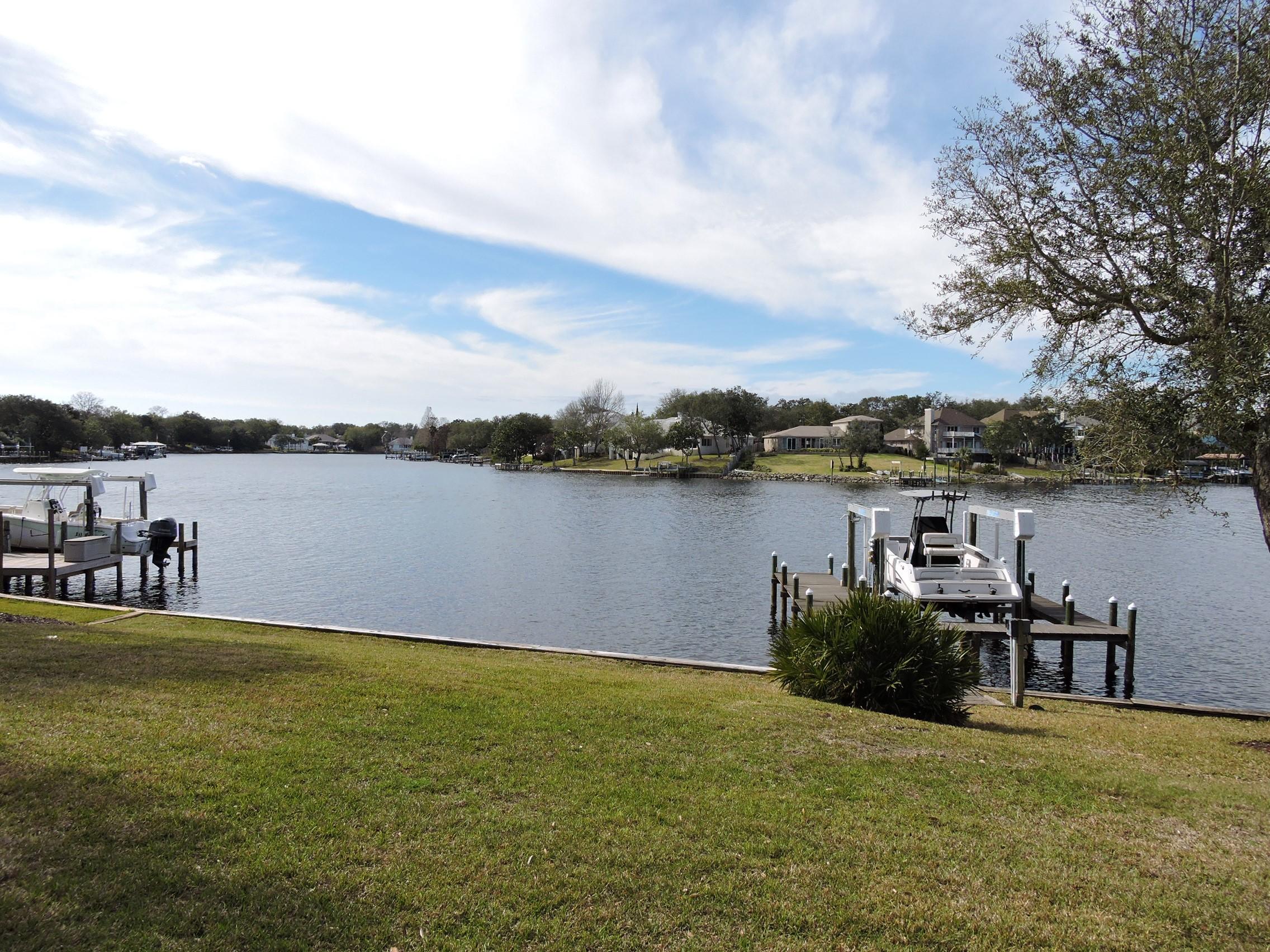 Beautiful waterfront home in the exclusive gated, Shalimar Point, waterfront neighborhood.  This home is all one story.  Lots of extras: Geothermal heating/cooling, hurricane rated windows with blinds inside of them, extended 2-car side entry garage, gas home generator, dock, boat lift.  Kitchen is spacious, has upgraded white appliances, and TWO pantries.  Fantastic split floor plan offers lots of privacy and space for everyone!  Master bedroom plus one bedroom on one side of the home.  Two more bedrooms on the other side of the home.   This home has 3 full baths - and one is set up with easy access to the lanai - which would make it ideal for a pool bath if you so desire one. Very convenient to all the bases/beaches. Quick boat ride to Destin Pass.