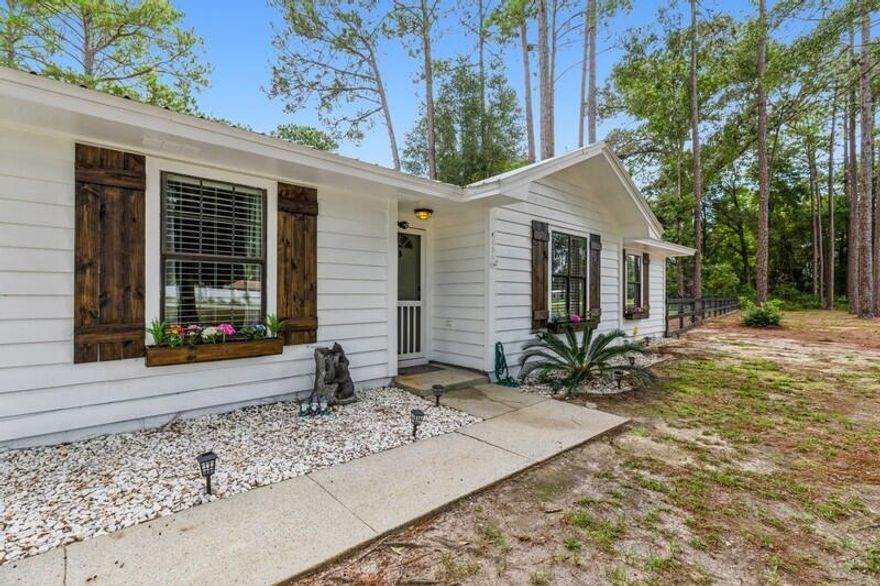 BACK ON MARKET NO FAULT TO SELLERS Exquisite Ranch Style Home with more than an acre of cleared land. This property is a eye catcher and you will quickly notice the exterior appeal. From the 6 year old metal roof and freshly painted white exterior that complements the custom wood shutters gives an absolutely gorgeous Farm House style look. This property also has a newly fenced backyard, freshly poured 24X32 concrete slab in front of garage and added asphalt millings for drive way. The land was cleared and cleaned from all brush and removed over 100 trees to give more yard space. There is an above ground pool in backyard.  The interior of home was fully painted and new hardwood flooring have been added in all bedrooms and living room area. The bathroom have all new bathtubs installed.