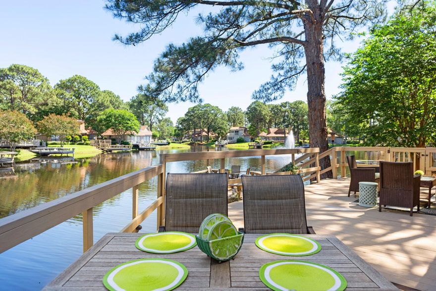 RESORT LIFE AT ITS BEST!!Outstanding opportunity if you have been looking for fabulous water views, privacy, expansive outdoor space and no shared walls! This adorable and cozy cottage is  surrounded by mature trees boasting a screened in porch, oversized outdoor deck overlooking lake and fountains PLUS a dock on the lake! New roof in 2024, updated kitchen and baths,offered fully furnished and ready to enjoy or rent. Golf cart parking/charging right out front and a HUGE attached storage shed included. The newly constructed community pool is just down the road!