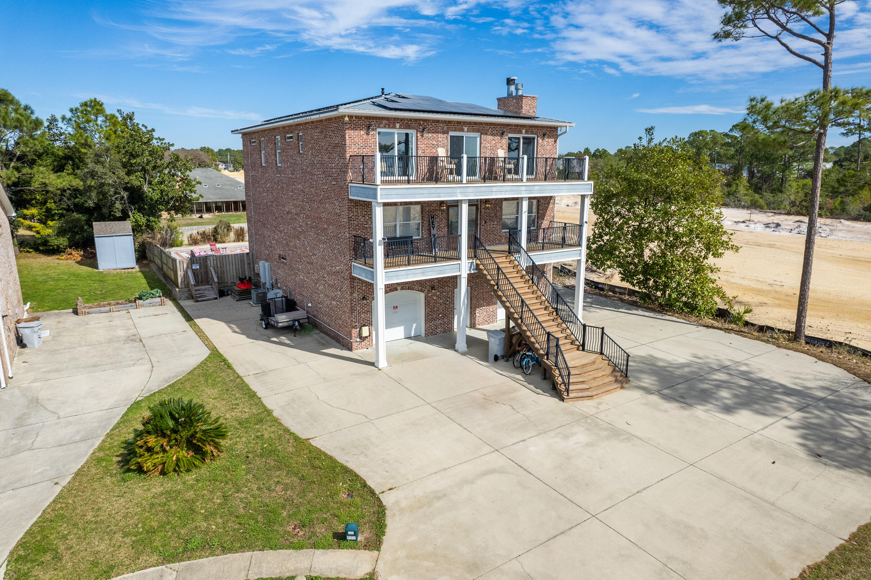 Welcome to Schooner Court, all brick, three story home that provides an abundance of space for the entire family and a bonus mother in law suite on the ground floor. This is an additional 980 SF that is not added in the original square footage. The home provides over 6 rooms and 5 bathrooms on a multi level layout. This amazing solid home was built to last. The balcony views provide Navarre Beach sunsets and morning sunrise views from the Eastern side. Beach access right across the street from the home that also provide unobstructed views on the water. The home has a large feature sheet, inclusion list, and paid off SOLAR on the metal roof, so please read that over. The home has currently been on an AIRBNB and has grossed over 100k each year. You can continue to use the home as passive income or move the entire family here to enjoy daily. 
The home is situated on a private cul-de-sac with more than 10 parking spots available. Underground utilities in the neighborhood and no HOA. 
Being your RV on the right side of the home and it also has professional installed EV hook up for 2 vehicles. The downstairs has a private suite with mini kitchen, 1 bedroom, full bathroom and living room for MIL or other use. The right side is still a full garage but currently used as a home gym. The home can easily convert back into the second garage on the left side with eliminating the downstairs bonus living room. So many options with this custom layout! The backyard features a heated pool, 7 person hot tub, covered patio space and decks for entertaining! This home is a must see! It's amazing to have a water view home without the waterfront price tag. 