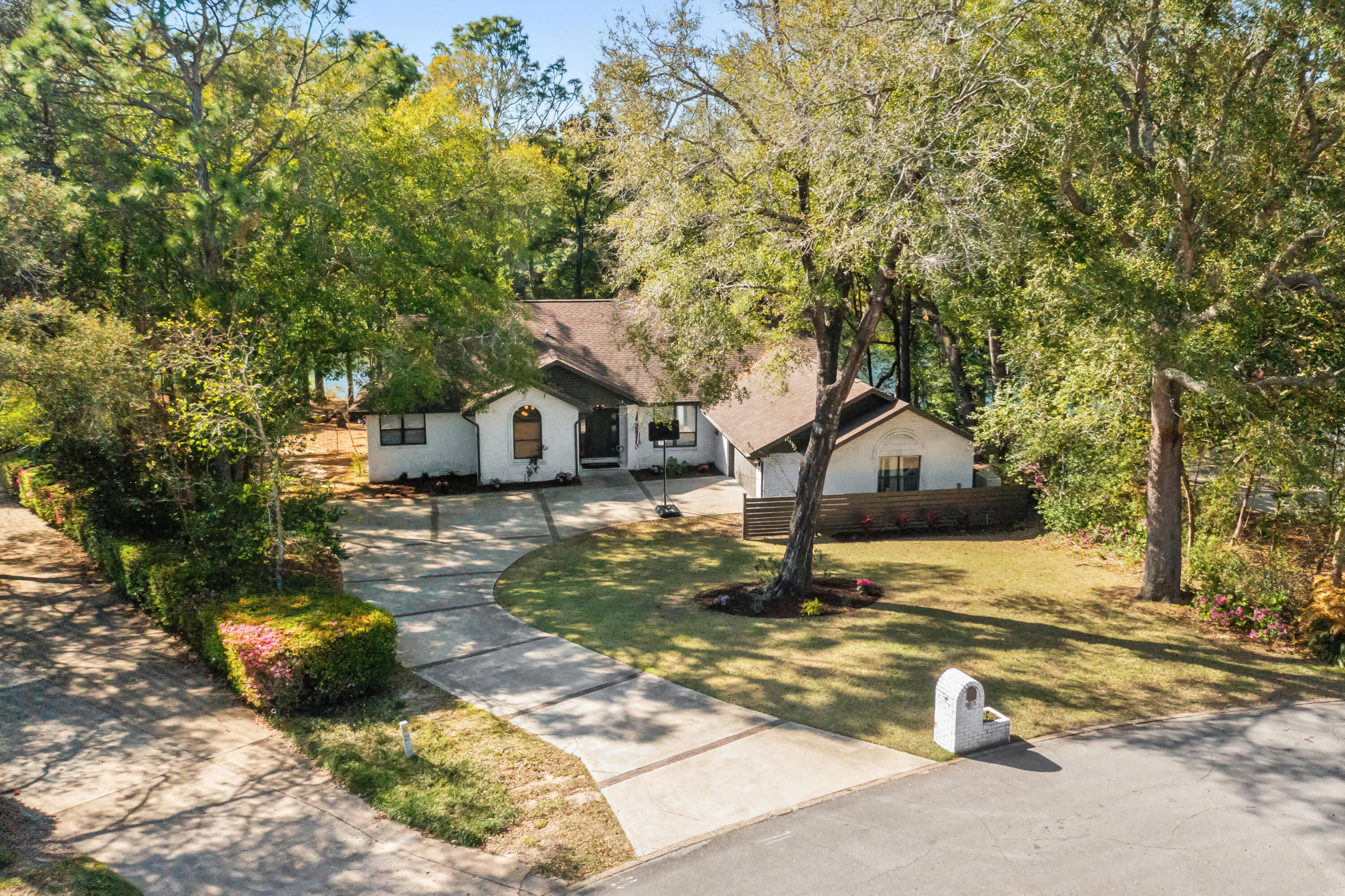 A ONE OF A KIND renovation! Surrounded by mature landscaping on the largest lake front lot in the neighborhood, this fully remodeled, four bedroom home is a show-stopper! With a timeless interior design, this home features an open concept with a split floor plan and direct lake views from nearly every room. Upon entry you a greeted with 17th century French stable doors highlighting a flex room commonly used for an in-home office space. The large Foyer has a board and batten accent wall and an art deco sconce that opens to a formal dining room overlooking the lake. Perfect for entertaining, this space is centered around a stunning Venetian plaster fireplace, beverage bar, and additional cabinetry for storage. A neutral, white Oak engineered hardwood runs throughout the living spaces. The heartbeat of the home is the kitchen! Centered in between the formal dining and indoor/outdoor living spaces, the kitchen is an easy flow in any direction with large windows that allow for natural lighting when you start your day. With floor to ceiling cabinetry, a Viking gas stove with custom range hood accented by a brass pot filler, 42" GE Monogram refrigerator, stainless steel appliances, quartzite countertops, and gorgeous hardware, everyone is staying for dinner!
Next you will enjoy a peaceful view from floor to ceiling windows in the living area. This room overlooks the lake and an expanded deck that wraps around the back of the home, making it easy indoor to outdoor living with glass sliding doors.
This property maintains a single story floor plan. However, bedroom two features an upstairs loft area perfect for additional heated and cooled storage or a game room. The secondary bathroom has custom vanity with Carrera marble floors, Quartz countertops, custom cabinetry with a pull out step stool, and a deep soaking tub with separate walk in shower. All bathrooms throughout the home have unique light fixtures and hardware.
Across the home is the Primary Suite with both deck access and lake views. The room has double walk-in closets with wood cabinetry shelving and storage and a large spa-like en-suite. The en-suite has a large walk-in shower with dual shower heads, Steam aroma, and a glass enclosure plus a soaking tub with his and her vanity areas.
No detail was left undone with this home renovation! The homes has a lawn pump sprinkler system, whole house generator, outlet for an electric vehicle in the garage, and spray foam insulation throughout. Please ask about options to purchase furnishings. This home is also listed as FOR SALE.