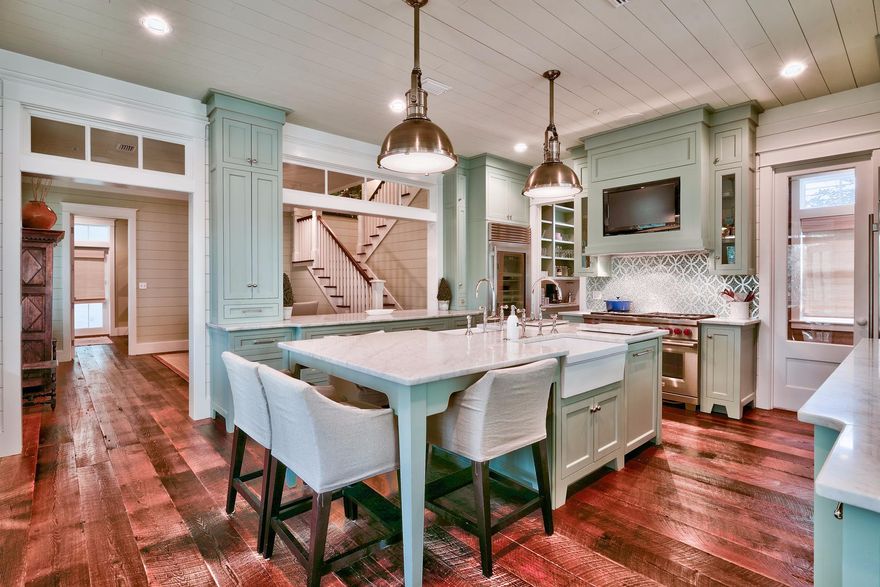 Stunning CUSTOM home in Watercolor. Interior Finishes and Furnishings selected by acclaimed designer Erika Powell of Urban Grace Interiors...Functional Architecture by Archiscapes and Quality construction by Baywoods Development combined to make this one of the finest homes built in Watercolor. Hand sewn wood flooring, reclaimed from a train station circa 1800's, flow throughout the main and guest homes. Painted tongue and groove wrap nearly every room in this coastal home. The first floor was designed with entertaining in mind. Open spaces surround a breathtaking kitchen. Subzero Refrigerator and Freezer, Wolf Range & butler's pantry. High end wood cabinetry topped with white marble. Dual farmhouse sinks are the kitchen's centerpiece. French doors give way to a wrap around porch, screened porch and outdoor grilling area. A spacious living area with brick fireplace, dining room, 1 bedroom with private bath, guest bath, laundry and office areas are also on the first level. Upstairs you will be greeted by whimsical bunk beds, barn doors and a laundry room sure to make you smile. With it's heavenly Master Suite and Master Bath, expansive porches and sleeping porch...The second floor is as impressive as the first.  2 guest bedrooms and bathrooms, a cozy den with wet bar and a light filled reading room complete this second level. Take a break in the game room as you make your way up to 4th floor where you'll enjoy 360 views of Watercolor from the the large tower room and widow's walk. A Beautiful Guest house with a full kitchen, living room, private bedroom and a bathroom is located above the 2 car garage. Large private lot has room for a pool. Home has been meticulously maintained. Other upgrades include an indoor fire suppression/sprinkler system and an alarm system for added safety and reduced insurance premiums. Sold furnished with some exclusions. 