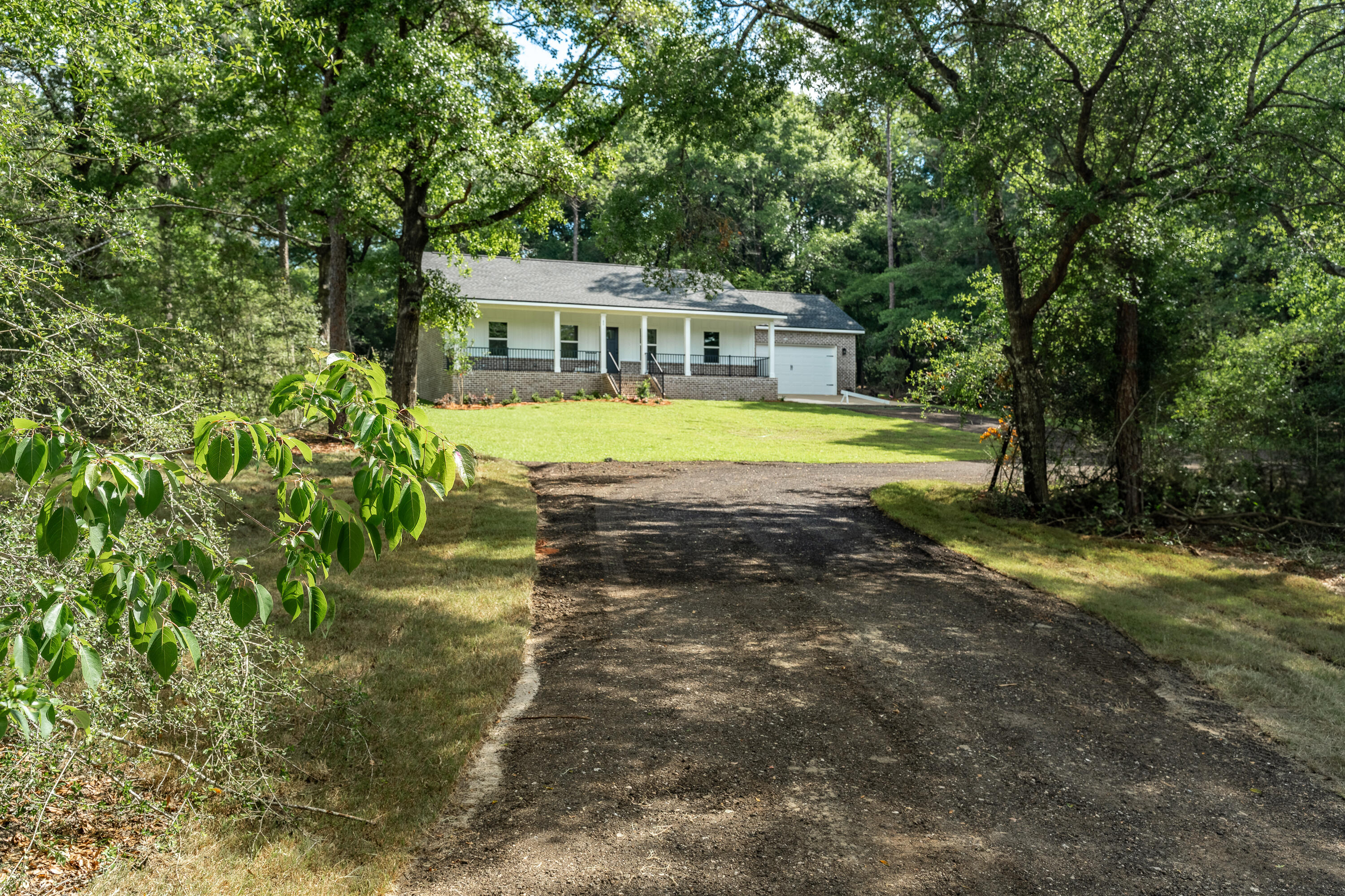 3.39 GORGEOUS WOODED ACRES comes with this BRAND-NEW HOME by quality local builder. So close to town, this beautiful homesite is nestled in the woods for privacy, a true ''diamond in the rough'' in the new home market! Home has been upgraded throughout to compliment a uniquely private and special setting. Covered front sitting porch is waiting for rockers and lazy evenings. Cathedral ceiling family room opens to kitchen w/work island & bar seating, cozy dining space, pantry, quartz countertops & upgraded mate black fixtures throughout. Craftsman finishes in baseboards, window trim and doors. Owners' suite has walk-in closet, tiled shower & double vanities. Laundry room has deep sink + extra closet. Covered rear porch, upgraded light fixtures, LVP thru-out, blinds on all windows.