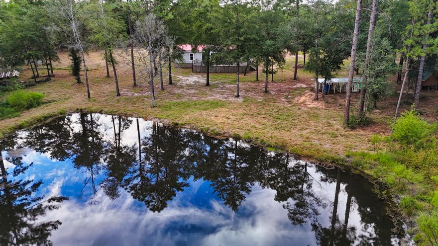 Presenting what North Okaloosa County dreams are made of; a 20 acre private ranch with everything one could desire about country life on the property. Located just off HWY 90, the property is nestled into quiet, natural serenity. As you pass through the front welcome posts to the ranch, you'll instantly be able to see the hard work, and tens of thousands of investments the prior owners have made to the property creating a dream come true homestead. 20 acres of land, a horse paddock with hot wire fence, pig pen, two chicken coops, and a quarter acre large stream fed pond ~8ft deep with fish. The possibilities of this home are truly endless, and they begin by being able to save over $500/mo at a minimum by boarding your own horses in the paddock. The overhang built to keep hay dry can be skinned into a stable without difficulty. The upgrades to the property are extensive. Beginning with the animal enclosures, the pig pen is by the leading edge closest to the entrance. There are two subsequent chicken coops next to that, one designed for breeding and separating, and the other for livestock holdings with self sufficient feed and water systems (feed and water once per week, collect eggs on Sunday). A 40' high tube container conveys for storage purposes. The pond has a built in functional dam with overflow relief system. A bridge over the pond is reinforced to withstand vehicle travel. The well pump system resides inside an insulated pump house, new pressure tank, pressure switch, power line from pole to pump, and PVC from well to house, featuring a heavy duty well pump filter. 2021 HVAC unit on the interior, roughly 500sf of new subfloor, and a heavily renovated kitchen consisting of new cabinetry, counters, LVP, paint, lighting fixtures, shelving, doors and door frames. The home has all brand new windows throughout, hurricane rated with a metal roof. 

Perhaps the greatest part of all is this entire ranch is eligible for VA/FHA financing, opening it up to the masses. These do not come around often, and if running a full time ranch has been a dream of yours with more acreage than nearly any neighboring property, this is the one. Book your private showing for this truly special property. 