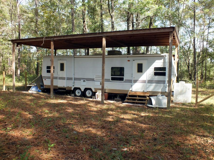 Great getaway retreat or a place to build your permanent home on a private 7 acre partially cleared parcel, approximately 10 miles north of the Ponce De Leon I-10 exit. The property has a 33 ft Luxor travel trailer with a covered roof in excellent condition with power, well and septic in place .