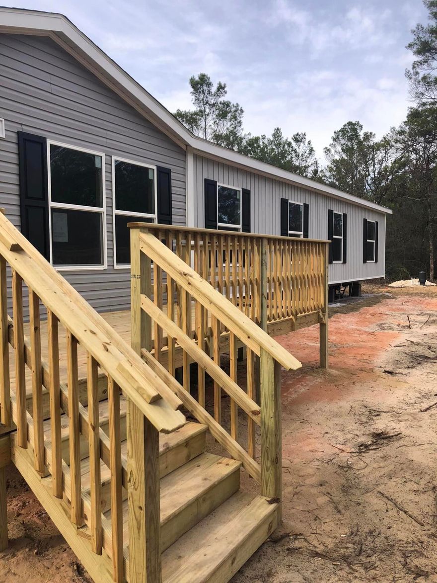 Make it HOME in time for the NEW YEAR!! This BEAUTIFUL five bedroom, three full bath home is just right for your family needs!! Wow what a great open floor plan with a split bedroom layout. Great kitchen with an eat in breakfast bar-prep center. This home includes all the kitchen appliances.  Bring the pets and plan on that spring garden!! Approx FIVE acres of wooded property with your home smack dab in the middle for lots of privacy! Driveway and final set up is being done right now.  Complete with well and septic, and a pump out for your RV!! Property is a cut out from parent parcel.