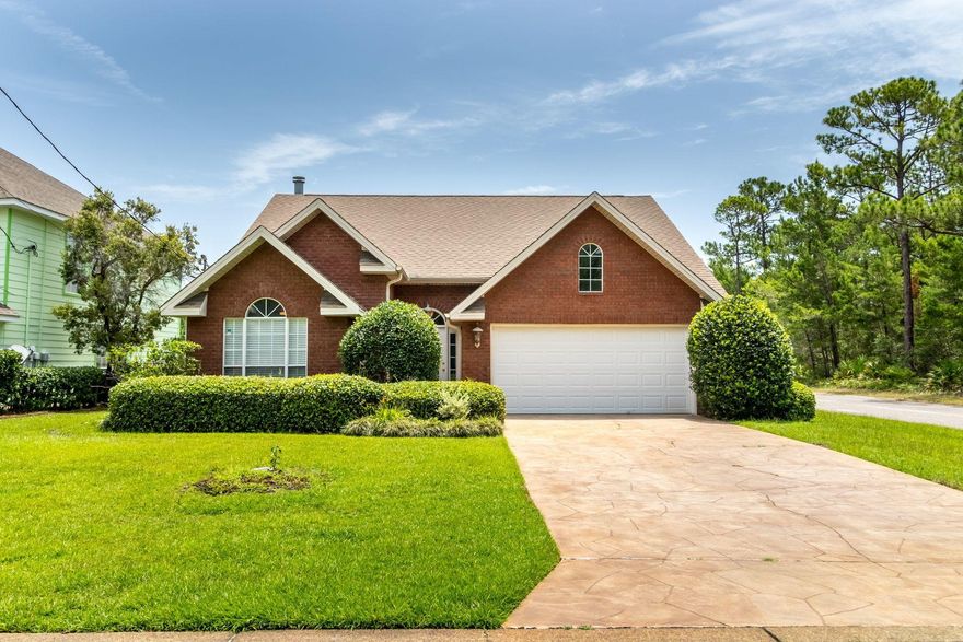 This lovely brick home has great curb appeal and is move in ready. Located on a Lakefront corner lot in Miramar Beach with NO HOA fees. With 3 Bedrooms/2 baths all on a single level, this is a smart investment as a rental property, second home or full-time residence. Key features are the 2-car garage, spacious split floorplan with kitchen, pantry, breakfast bar and dining/living spaces with vaulted ceilings. The large master bedroom has a walk-in closet, and double vanity bathroom with garden tub and separate shower, while 2 guest bedrooms share a hallway bath. Designated laundry room is conveniently located. The living space is extended outdoors by a screened porch where you can enjoy the birds and frogs singing and lily pads in bloom, or let the dog run in your private fenced back yard.