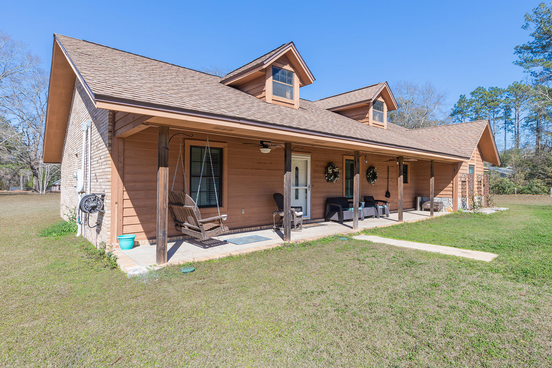 Charming 4 bed/ 2.5 bath country home on over an acre of land! Beautiful BRAND NEW engineered hardwood flooring and fresh paint throughout. Large living room with beamed cathedral ceiling and French doors that welcome you into the Florida room (not included in the SF). Countertops and cabinetry abound in the sweet country kitchen, complete with a large pantry. The master bedroom offers a walk-in closet, and en-suite bath with double vanity. Additional separate den is the perfect space for entertaining or to retreat after a long day. Home features custom Plantation Shutters throughout. Outside you'll find plenty of space for pets, play, and gardening, or just to enjoy the peace and quite. In addition to the 2-car carport, there is an additional 1-car attached garage/workshop.