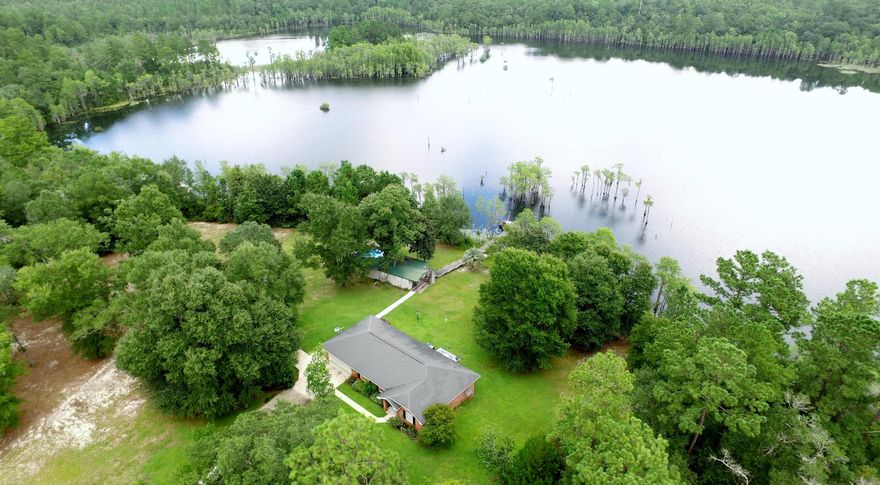 Dreamy Waterfront Oasis! This is an ideal second home located just a few minutes from the 18 hole Sunny Hills golf course. Additionally, there is a guest cottage with a pool on the property. Together, both homes comfortably sleep 8 people and can be sold furnished or unfurnished. The property features 240 ft of waterfront with a long fishing pier. There are currently only 3 homes on Gin Lake as the majority of the lake is greenbelt land owned by the subdivision. The beautiful main brick home was built in 2003. Wonderful features of this home include 18'' tile flooring, whirlpool tub, walk-in closet, great views of the lake, breakfast room, sidewalks, storage building, and water softening system. Sunny Hills has several lakes and a clubhouse. Both homes are on a water filtration and softening system. Home warranty being offered to the buyer at closing. Sunny Hills is located within 12 miles of the interstate, within 45 miles to the international airport and The World's Most Beautiful Beaches of Panama City Beach. 