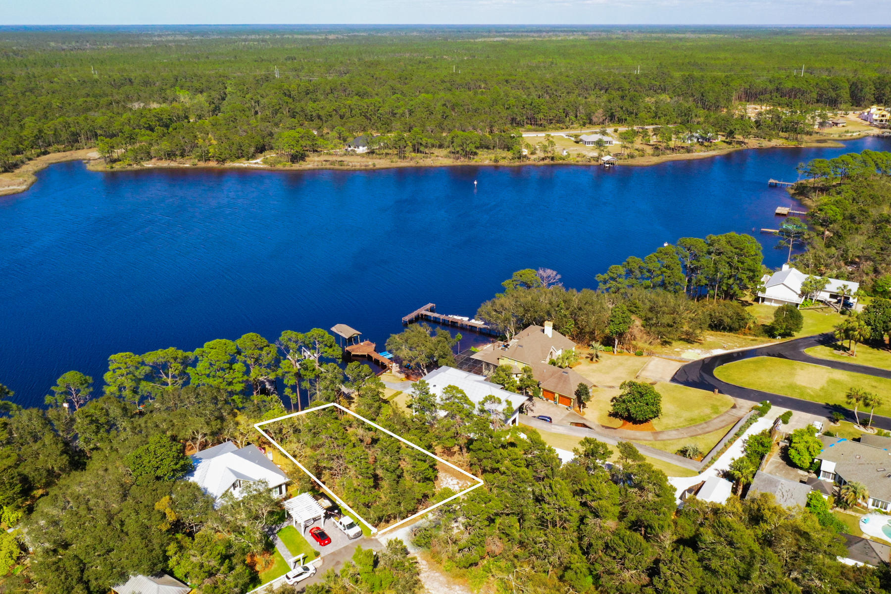 Occupying one of the highest elevations on Lake Powell, this wooded lakefront home site measuring 87 feet wide and 180 feet deep offers 0.36 acres on which to build. There's no HOA, and a seawall and dock are already in place. It's just waiting for a new owner to add their own special home for enjoying the peaceful lakefront lifestyle. Imagine swimming right off your own dock, or fishing in the brackish water which supports both freshwater and saltwater fish. Lake Powell is a rare coastal dune lake, found only in a few places in the world. It is the largest on the Florida Panhandle and holds the coveted designation of being a ''Pristine Florida Waterway.'' The calm lake waters are ideal for kayaking, canoeing and stand-up paddle boarding.