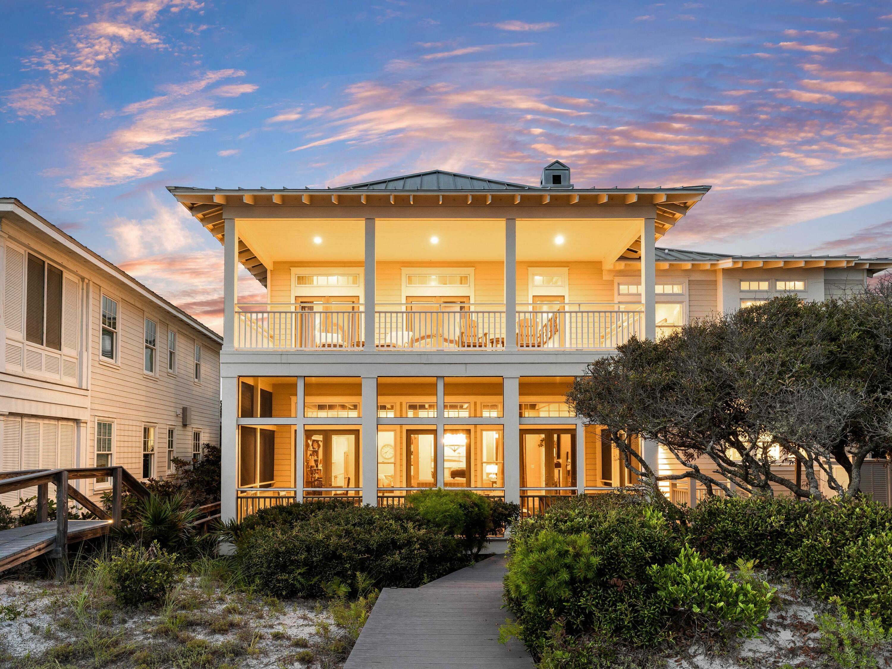 Presiding over serene dune, lake and gulf views, this quintessential beach house is in an exclusive private beach neighborhood. It comes with its own coveted Trex-plank walkover to the pristine white beach. Airy 12-ft. ceilings with dark wood beams enhance the great room, while the updated chef's kitchen boasts granite countertops, stainless appliances and an island with a cooktop. Perch on stools at the lengthy bar for casual dining and conversation. Tile floors and double-aspect windows invite you to a large screened porch with panoramic views extending across Draper Lake and the Gulf of Mexico. The oversized balcony on the second floor is perfect for laid-back entertaining and toasting sunsets from this enviable location. Four of the six bedrooms share the same breathtaking gulf views.