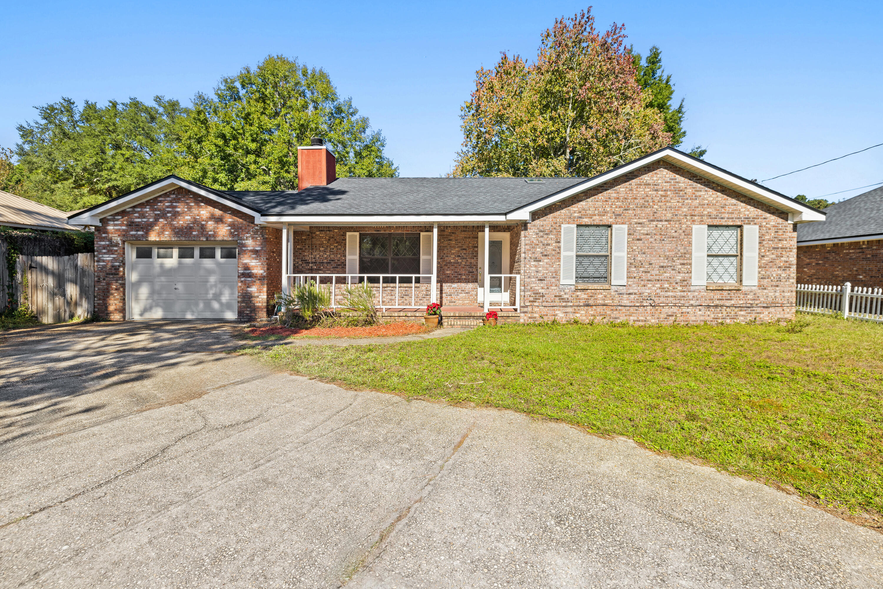 Affordable housing in a location that is central to Ft. Walton, Destin, and Crestview. One-story all brick ranch home is situated on just over a quarter-acre lot. Covered front porch is a perfect host to a pair of rocking chairs. You can easily find yourself enjoying your latte as dawn breaks. Upon entering the frosted glass front door, bedrooms are located to your right, and the living area to the left. The solid surface flooring minimizes allergens;  all interior ceilings have had the popcorn texture removed. The heart of the living room has a wood-burning ''field stone'' fireplace and hearth. The mantel will look great with your Christmas stockings. The dining area should comfortably seat six for Christmas dinner. Spacious kitchen has a pantry, Click ''Read More' a Frigidaire fridge (sold as-is); and plenty of counter space for holiday meal prep. The window over the double stainless-steel sink looks out to the backyard. The interior laundry room comes with washer and dryer (sold as-is) and has a bank of cabinets overhead for storage. One car garage has an alcove with built-in ventilated shelving and another alcove has a personnel door leading to the backyard. The attic space is equipped with pull downstairs and some nice floored space.  Metal storage shed is great for storing your holiday d??cor and has power. A fully privacy fenced backyard is an open pallet for you to design your favorite flowers and veggie garden. Even room enough for a pool for the upcoming summer season. One year Fidelity Home Warranty is being provided. A new dimensional shingle roof was installed spring of 2024 by Timberman Roofing. This neighborhood has no monthly dues or covenants.