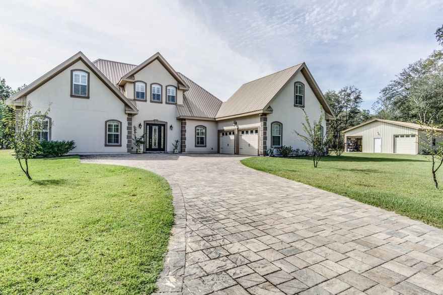 Beautiful 10.10 acre Estate property with pool and workshop less than 25 minutes to the beautiful beaches of the Emerald Coast! This incredible property sits majestically behind iron gates on a picturesque parcel of land. The long paver driveway leads to an impressive 2 story custom built home with a courtyard entry garage. As you enter beautiful double entry doors you will appreciate the spacious open floor plan and custom details. The master bedroom and one additional bedroom are located on the 1st floor, upstairs is a bedroom, bath, and a huge man cave/bonus room. The large open kitchen overlooks the living room which features a 2 story ceiling and French doors opening to the beautiful pool. The home features all the custom upgrades you'd expect plus some! The fully fenced property