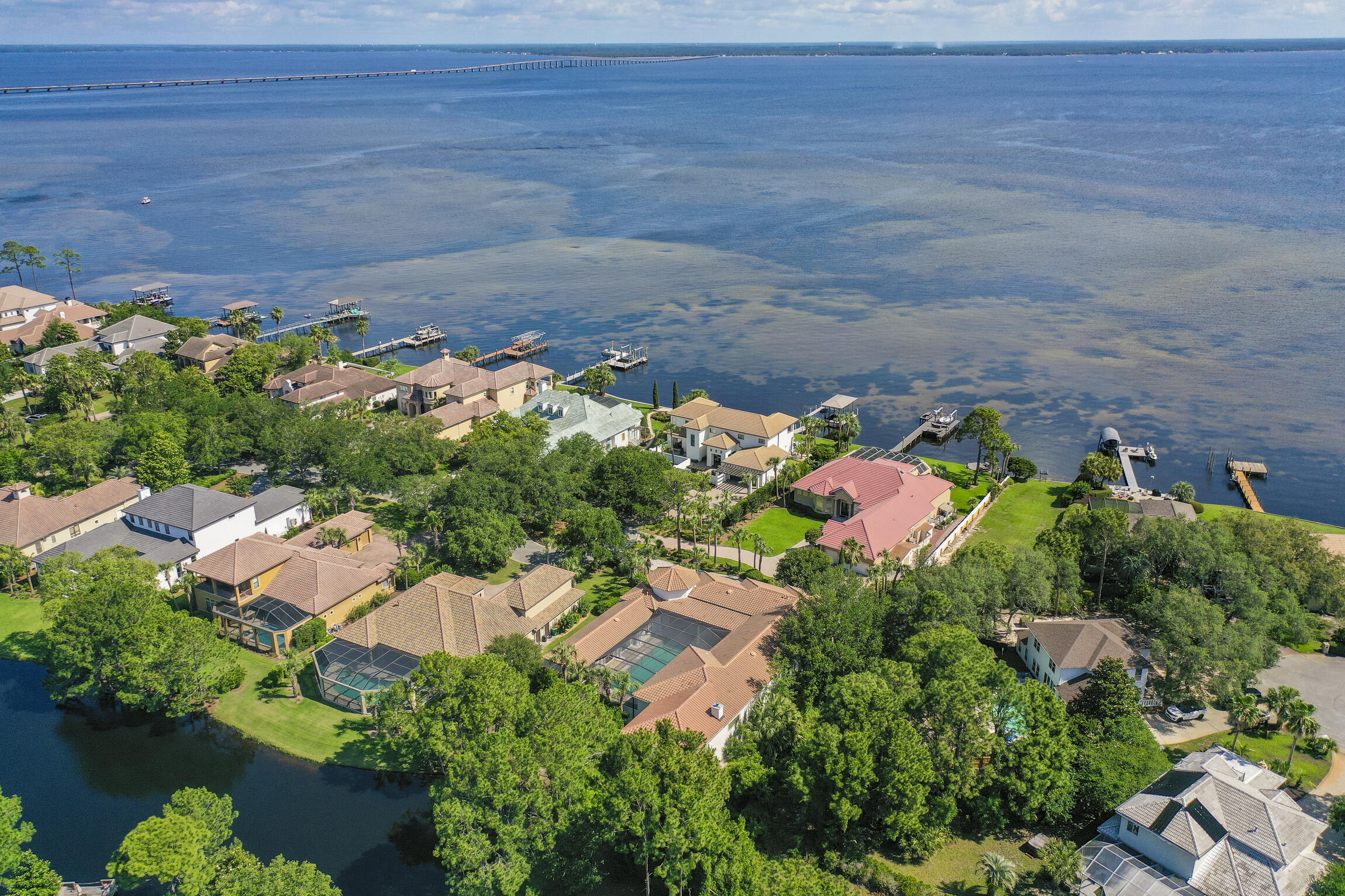 455 Admiral Court, located in the prestigious Regatta Bay community, is an exceptional residence that embodies tranquility and luxury. This custom-built, single-story home spans over 5,000 square feet and is situated on a half-acre lot, offering a picturesque lake view that enhances its serene atmosphere. The property has been recently updated with the addition of a sumptuous 2-bedroom, 2-bathroom suite, showcasing the seller's commitment to quality and comfort.As you approach the house, you're welcomed by a breathtaking outdoor scene featuring a grand pool, coy pond, and meticulously landscaped greenery, all enveloped by an expansive brick paver patio that extends the living space outside. This inviting environment is absolutely perfect for entertaining or simply relaxing in the calming embrace of nature.

Upon entering the main home, the eye is drawn to the 80-foot gallery library, boasting floor-to-ceiling bookshelves that create a visually stunning focal point and provide ample space for a vast collection of literature or personal artifacts. The library is a testament to the home's sophisticated design and attention to detail. French shutters, intricate plaster molding imported from England, molding trims are replicas from 12th century French cathedrals and abbeys. Columns grace the passage from the library into the formal dining room, which has built-in chine cabinetry, wet bar and entry into the butler's pantry and the kitchen beyond. 

The main house has 20-foot ceilings throughout and features a massive master suite, additional bedroom, and bathrooms that exude elegance and comfort. This entire home has been thoughtfully designed to maximize natural light, with the primary focus on the elegant courtyard pool. The design truly separates this abode from all the rest and creates a real sense of privacy, peace, and tranquility.

The 3-bedroom, 2-bathroom addition is a retreat within the home, offers a private sanctuary for guests or multi-generational living, giving everyone plenty of privacy and space, and further creating a cohesive and opulent living experience. 

With its prime location in Regatta Bay, residents enjoy the exclusivity of a gated community along with access to a wealth of amenities, including a community pool, tennis courts, and a boat dock for waterfront activities. This home is not just a place to live; it's a lifestyle choice that offers the perfect blend of comfort, luxury, and outdoor living. If you're looking for a private oasis that reflects your refined tastes and appreciation for the finer things in life, 455 Admiral Court is a must-see.