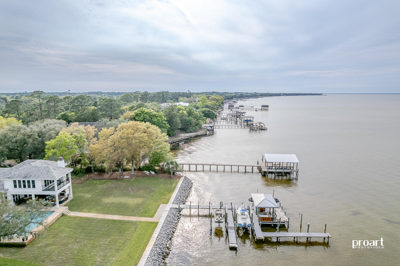 Welcome home to the highly coveted community of Estates at Indian Pointe.  This custom built one owner retreat is positioned on an expansive 1 acre lot with 115 feet of water frontage on the beautiful Choctawhatchee Bay.  This true estate begins as you enter the gated driveway that winds beneath a canopy of beautiful mature oaks and ends with panoramic views of the bay as well as some of the most spectacular sunsets found anywhere in Destin!  This 5 bedroom and 4 bath home is ready to impress as soon as you open the front door to find a beautiful open floor plan that immediately encompasses the expansive water view.  Large living room with coffered ceiling has 4 panel glass sliding doors and surrounds an impressive floor to ceiling wood burning fireplace with gas lighter.