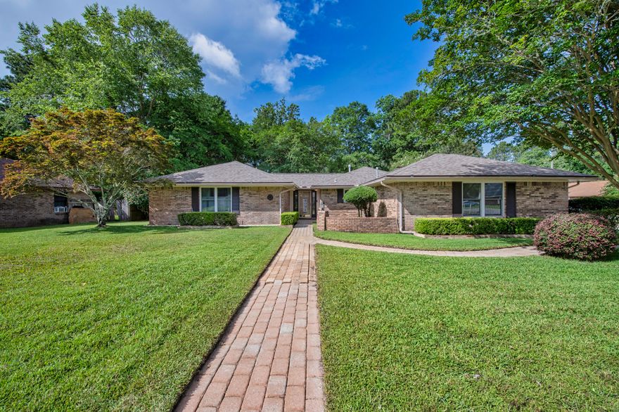 Charming 3-Bedroom Home on Spacious Corner Lot with Stunning Outdoor Living! Welcome to this beautifully landscaped, and well-maintained 3-bedroom, 2-bath home nestled on an oversized corner lot, offering both space and privacy. Enjoy the ease of a 2-car side-entry garage with a charming brick paver walkway that wraps around the home. Step inside to find a thoughtfully designed floor plan with tile flooring throughout for low maintenance living and a Patriot Carbon Filter for cleaner indoor air. The heart of the home features a cozy wood-burning fireplace, perfect for cool evenings and adding warm ambiance to the living space. The spacious kitchen boasts granite countertops, stainless steel appliances, soft close drawers and solid wood cabinetry, ideal for everyday use and entertaining. The Primary bedroom has a large walk-in closet and ensuite bath for your comfort.  Soft close drawers in both bathrooms. Enjoy Florida living year-round in the Florida room, offering panoramic sweeping views of the beautifully landscaped back and side yards. Moving outdoors to a large open patio ideal for relaxing or hosting gatherings and a private covered patio off the dining area provides another serene outdoor retreat. The fully fenced backyard includes a storage shed for lawn equipment. Home currently has a Termite Bond in place through June 2028. Major updates include: A/C (2015) added Patriot Carbon Filter (2025), gas water heater (2017), roof (2018), and a new stove (2024).  Home is move-in ready, includes washer and dryer and back patio has been wired for a hot tub!