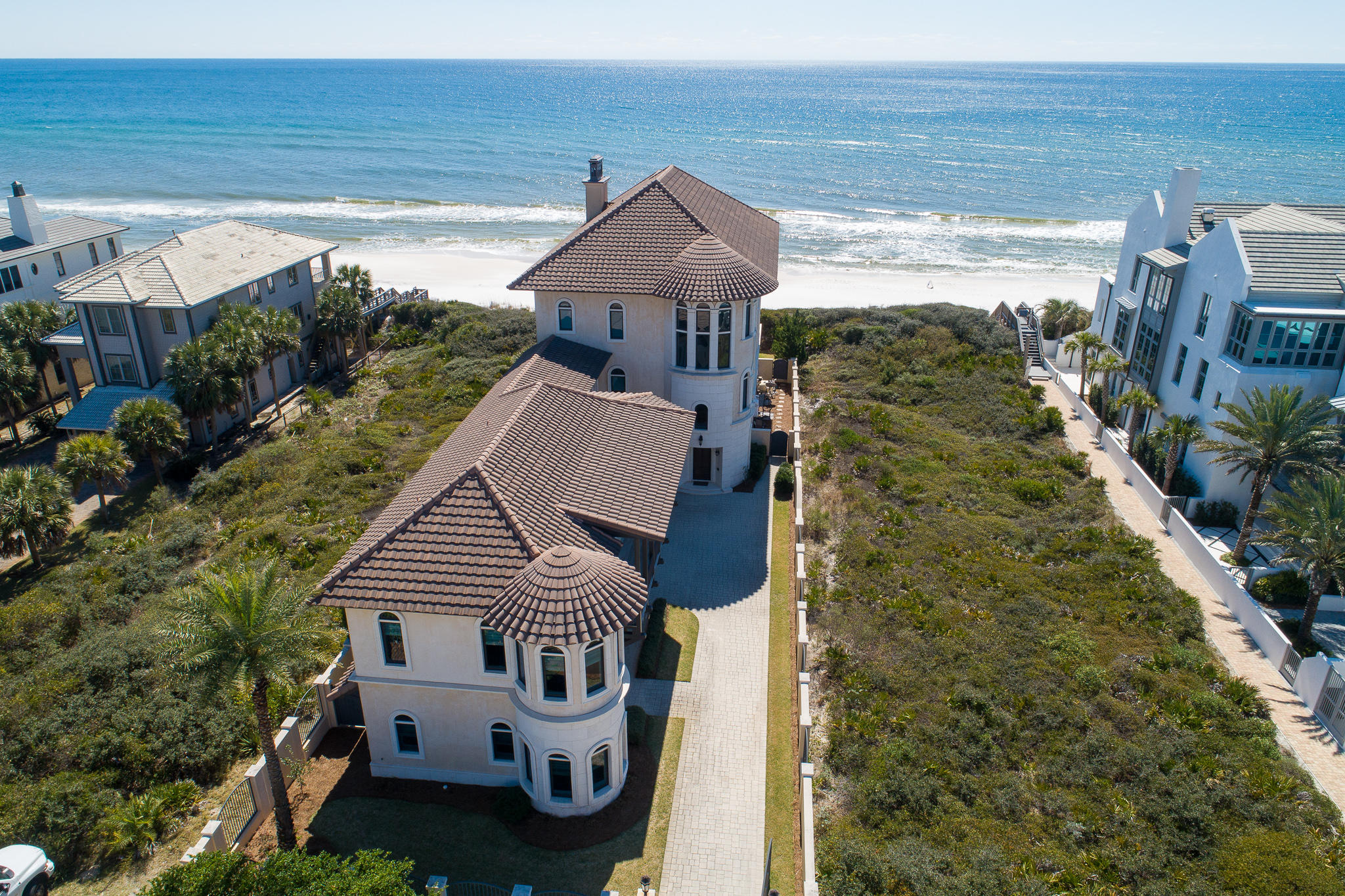 The culmination of meticulous craftsmanship & materials from around the globe, this 7-bedroom, 10-bath Mediterranean estate is a work of art in prestigious Paradise by the Sea. Designed by renowned architect Darrell Russell of A Boheme Design, the home's grand volume is accented by marble floors, hand-applied Venetian plaster, and an elaborate three-story spiral staircase. Beautiful millwork, crown molding, arched windows, columns, and coffered ceilings can be found throughout the home's impressive 8,729 square feet.The main living area takes full advantage of the unspoiled coastal views, providing the perfect backdrop for entertaining, corporate retreat or family gathering anchored around the gas fireplace.