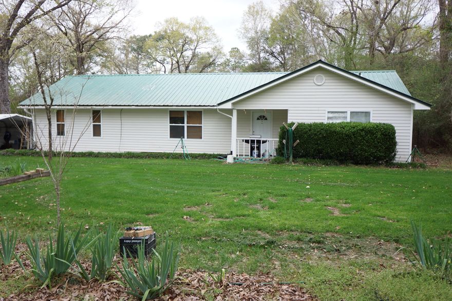 What a great property, 1.68 acre lot with a nice home just minutes from everything. This can be your country retreat or farmlet. The road frontage has been left in its natural state to give you privacy, the property is fenced and has a gated entrance. The home has a large screened deck, detached carport, workshop with its own carport, storage building, several garden areas and a detached open patio with a fire pit. This home has both a den and living room, open kitchen/dining area updated appliances, newer A/C and metal roof. If you want convenience and privacy this is the home for you. Just picture yourself enjoying the quiet peaceful times on your screened deck or sitting around the fire pit. Seller is providing an Old Republic Home Warranty with an acceptable offer.