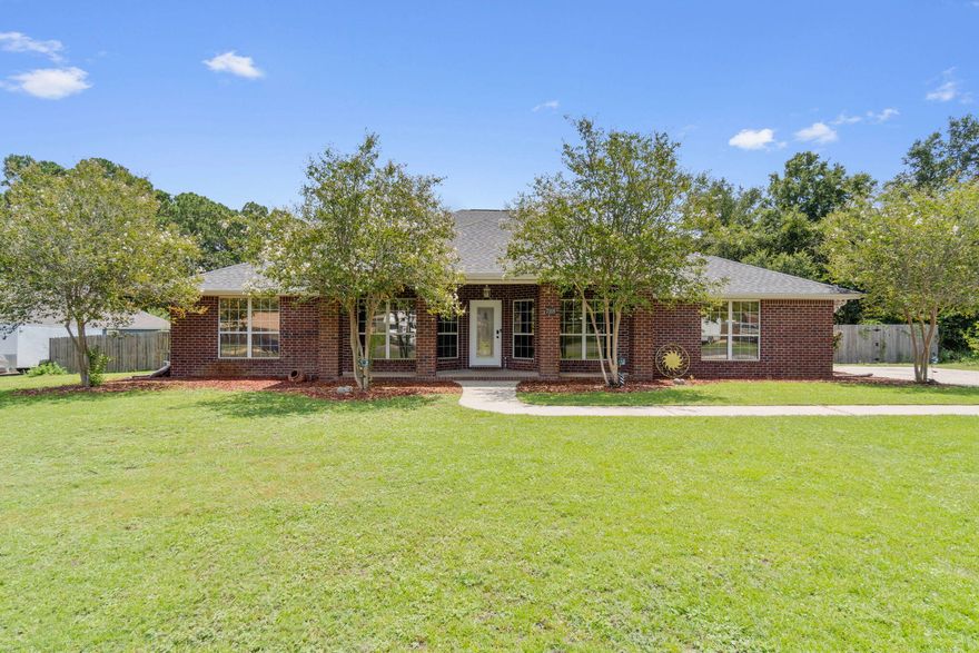 *1.5 acre property!* Welcome home to this lovely all brick 4 bed (plus a huge 20x20 bonus room, formal dining room, AND enclosed Florida room), 3.5 bath POOL home sprawling over 3,131 sqft in Navarre nestled on 1.5 acres just minutes to the beach with NO HOA. This home features hard surface flooring throughout (tile and newly installed luxury vinyl plank flooring), a huge kitchen with newly resurfaced and painted cabinets), surround sound wired throughout the house, raised ceilings and a long list of updates! Have peace of mind with a 2019 roof, 2023 HVAC system, and 2023 water heater. Want to have your own homestead or just enjoy having extra space to use or build on? With a chicken coop, grape vineyard, blueberry grove, persimmon tree, a clementine tree, and a workshop you're going to love what's already here but also the possibilities of what it could become on this unique lot! The house and pool are situated on 3/4 acre and the workshop, grapevines, blueberry grove, and chicken coop are on an additional 3/4 acre (all 1.5 acres are one parcel). This is the perfect location close to schools, shopping, and the beach, but secluded enough to have a country feel. Don't miss this opportunity to own a wonderful and rare retreat!