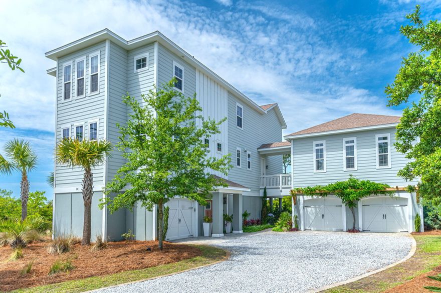 Coastal charm abounds in this stunning home. Panoramic water views of the Sound allow you to sip your coffee and watch the dolphins play. Situated at the end of a cul-de-sac, you'll truly feel immersed in nature surrounded by mature trees and marsh grasses, with ospreys soaring overhead. Upon entering you will find a large, welcoming foyer complete with custom built-in mudroom. The main floor features an open concept with 10' ceilings and opens to the exterior via four sets of French doors with access to the rear deck and pergola, an entertainer's paradise. A true chef's kitchen greets you with quartzite countertops, top-of-the-line appliances including a 6-burner gas stove with dual ovens, a walk-in pantry, and plenty of cabinets for storage. A home office features built-in bookcases,