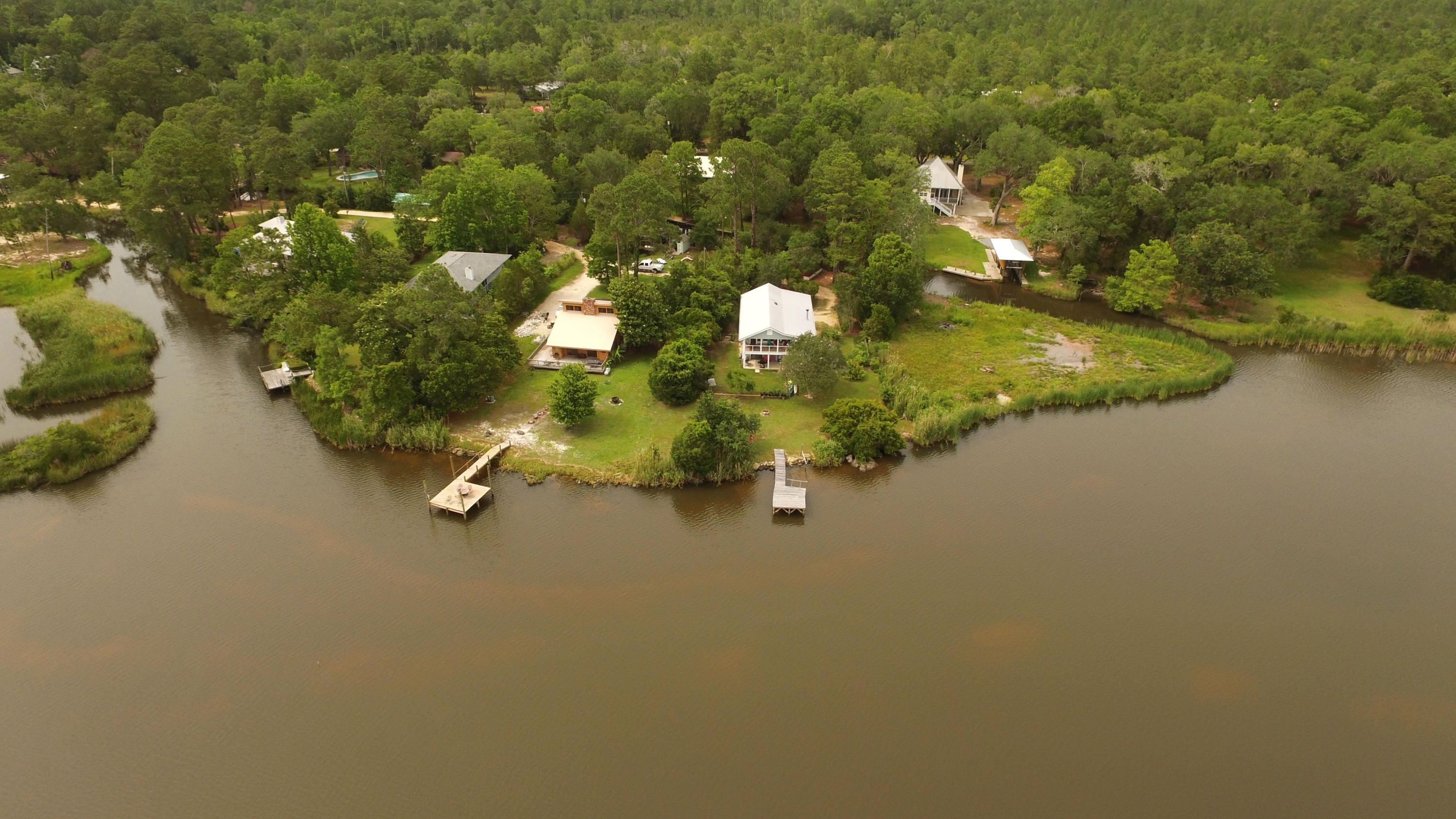 Waterfront Paradise with wrap around views of Jolly Bay! Ever dream about Island Living? This is it! This unique home shares an island with only 4 other houses. Picturesque windows and a large open deck allow for endless Bay views. The boat house with boat lift is located on a protected canal with direct access to the Bay. The kitchen, living room and dining room are all open and updated with wood floors, fireplace, corian countertops, plenty of updated kitchen cabinets, and spacious pantry. The first floor of the home is a vast storage area and a 12 x 16 room with a full bath that could easily be converted to a third bedroom. Upstairs are 2 bedrooms and 2 additional baths. Bring your paddle boards, boats, jet skis, and kayaks! This island home is a nature lover's dream!