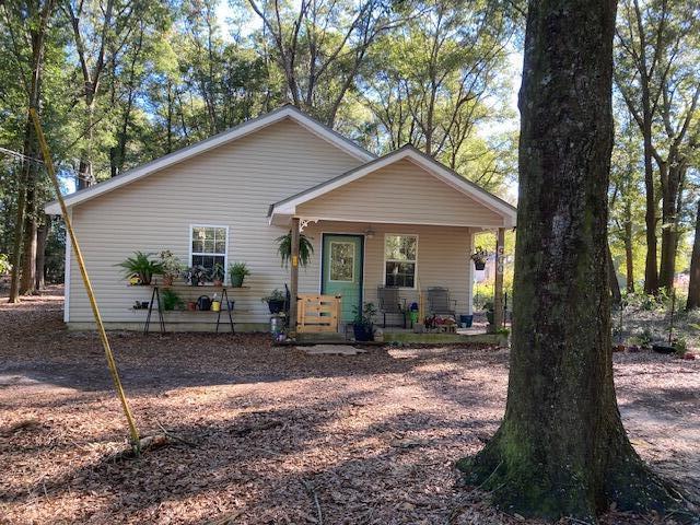New photos are coming soon! 7.89 acres of privacy surround the cutest 720 sq ft, one bed and one bath, cottage. The bedroom has ample room for one king bed or two queen beds. There is a washer and dryer in the hallway. Central A/C and heat. All electric. New water heater installed in September 2021 and new AC in 2023. The refrigerator and stove are new. The interior has been freshly painted. Front porch, the side, and the back are fenced for pets. Floors are all tile and there is no grass outside to maintain. Kitchen has a hanging pot rack and windows have blinds. Property has one utility metal shed on concrete slab. Furniture is negotiable. Scenic walking trails are on the property,