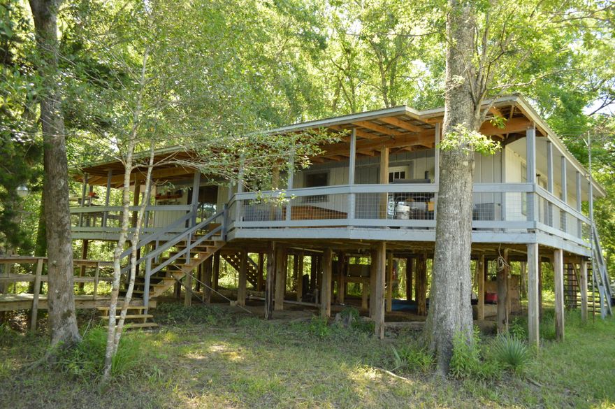 This is one of the most unique waterfront?river front homes in the area. The home was designed as a duplex by the owner but has been used as the family's private River getaway. The home has 4 bedrooms, 2 full baths, 2 separate kitchens, a large porch overlooking the river, walkway to a floating 2 Boat boathouse with electricity, large steel fish cleaning station and much more. This property is one of only a couple of lots in this area with a well and septic tank and the State of Florida has prohibited further development by refusing to issue permits any longer in this immediate area. This property could be used as a family get away or rented. Home is located on 2 lots, one vacant lot will be retained by the owner.