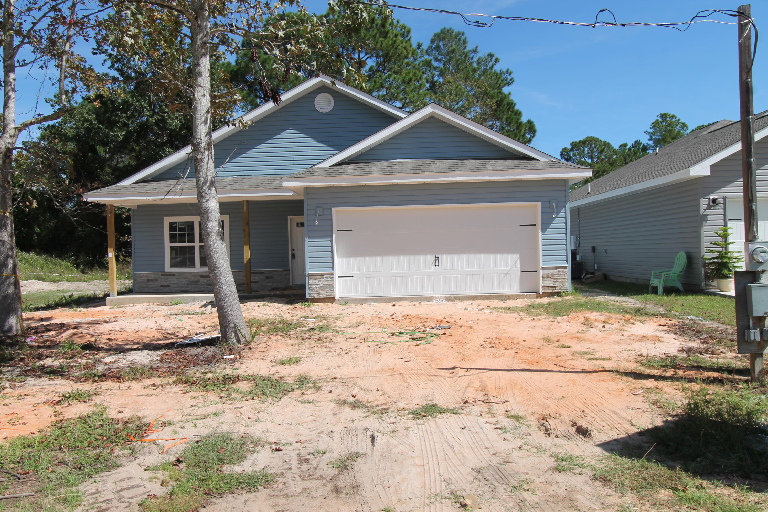 New custom 3/2 floor plan, with super curb appeal. Great location!!! Tom Street is on the North side of Hwy 98, just 1 minute past the Santa Rosa County line. 10 Ft. ceilings are throughout main living areas. Ceramic wood look tile flooring, is throughout main living, and wet areas. Kitchen opens to the dining area and has custom cabinetry, a breakfast bar, granite countertops, and stainless appliances, including a refrigerator/ freezer. Master suite has a trayed ceiling, 2 walk in closets, double vanity with granite countertop, and a whirlpool garden tub with separate shower. There is a covered porch with extended patio at the rear of the home, just off the dining room. The driveway is oversized; two vehicles may easily park next to one another. Yard will be fenced, prior to closing.