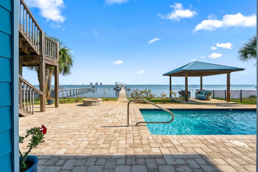 OPEN HOUSE June 21st 10am-12pm.Waterfront luxury in Gulf Breeze-only a short golf cart ride away from Tiger Point Golf Course. 2961 Bay St. offers 5-bedrooms and 5 bathrooms, a dock, pool & elevator. Enjoy breathtaking views of the Intracoastal Waterway, featuring a 250-ft pier with boat slip, lift, and two jet ski lifts, vinyl seawall, and new Trex decking. Enjoy resort-style outdoor living with a private pool and rock waterfall, gazebo, and an expansive balcony with built-in outdoor kitchen, gas grill, sink, and custom cabinetry.The main living area boasts a chef's kitchen with maple-glazed cabinetry, blue granite countertops, center island, flat cooktop, and built-in oven. The open floor plan flows into a spacious living room with a gas fireplace, surround sound...See more... and stunning water views. Ten-foot ceilings, crown molding, eight-inch baseboards & eight-foot solid-core doors.
The primary suite offers water views, reclaimed wide-plank pine floors, trey ceiling, and a spa-inspired bath with walk-in travertine shower, whirlpool tub, Kohler fixtures, and his-and-hers walk-in closets. You will also find an additional 2 bedrooms, full bathroom with dual vanities plus a half bath for visitors.  
The lower level functions as a complete in-law suite or income producing BNB with two bedrooms, two bathrooms, office, kitchenette, living area, and custom built-ins. Access both levels via a custom iron staircase or a cherry wood-paneled elevator. 
Additional features include:
* Wet bar and entertainment center downstairs
* Cypress ceilings and IPE decking on the porch
* Surround sound inside and on decks
* Hurricane shutters for all windows and doors
* Mahogany front door
* Ample storage throughout
* 2 Huge garages!!
Located just two blocks from a boat launch and minutes from top-rated schools, shopping, and Pensacola Beach. Enjoy southern exposure, cooling Gulf breezes, and unforgettable sunrises and sunsets from your own backyard. This is coastal living at its finest! 
