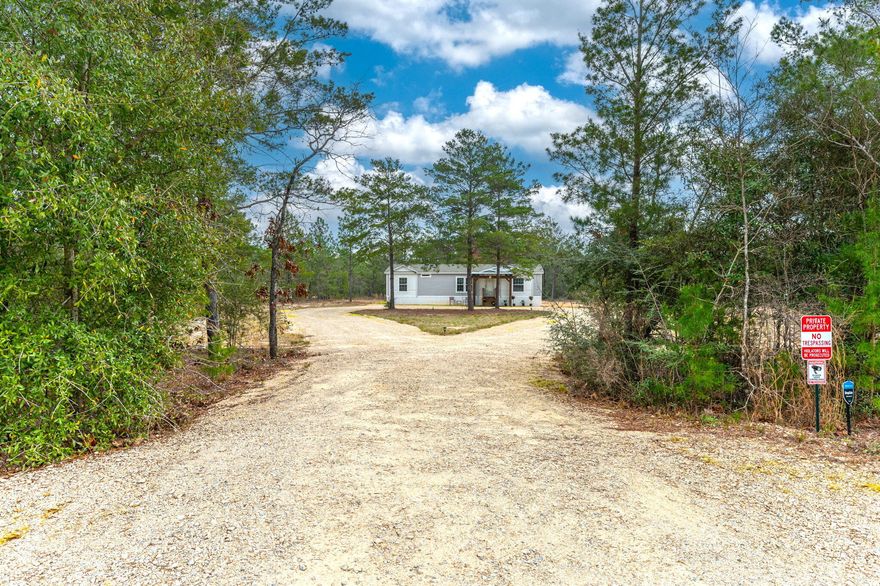 Welcome to your serene country retreat! Nestled on a spacious 1.60-acre parcel, pulling in you will notice the circular crushed concrete driveway. This meticulously maintained manufactured home, a mere 3 years young, offers a perfect blend of modern comfort and natural beauty. Located on a paved county-maintained road, the absence of HOA dues provides you with the freedom to truly make this property your own. Step inside to discover the inviting ambiance of this home, featuring wood-like laminate flooring that complements the cozy carpeting throughout. The heart of the home is the open-concept living area, where the kitchen seamlessly overlooks the living space. A large island not only provides additional workspace but also offers ample storage, making meal preparation a breeze. The