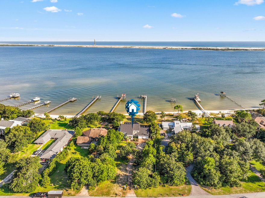 Introducing the sweet life of sunrises & sunsets across the Santa Rosa Sound at this stunning WATERFRONT paradise! Nestled on almost an acre with 100 ft of open water access is this beautiful 2-story stucco home that features 2 boat lifts, a dock with power & water, & an enclosed salt water POOL! The home boasts 4BR/3.5BA/4,026SqFt/2-car garage,  whole house generator, a 2023 roof, 2020 tankless gas hot water heater, 2021 hurricane rated windows & exterior doors, all new solid wood interior doors, new planked tile flooring downstairs, new pergo flooring upstairs, professionally and custom renovated kitchen, bathrooms, & wet bar, new gas & electric fireplaces, new LED lighting throughout, & TREX decking! Enjoy no HOA, X flood zone, & county property taxes! Short term rentals are allowed!