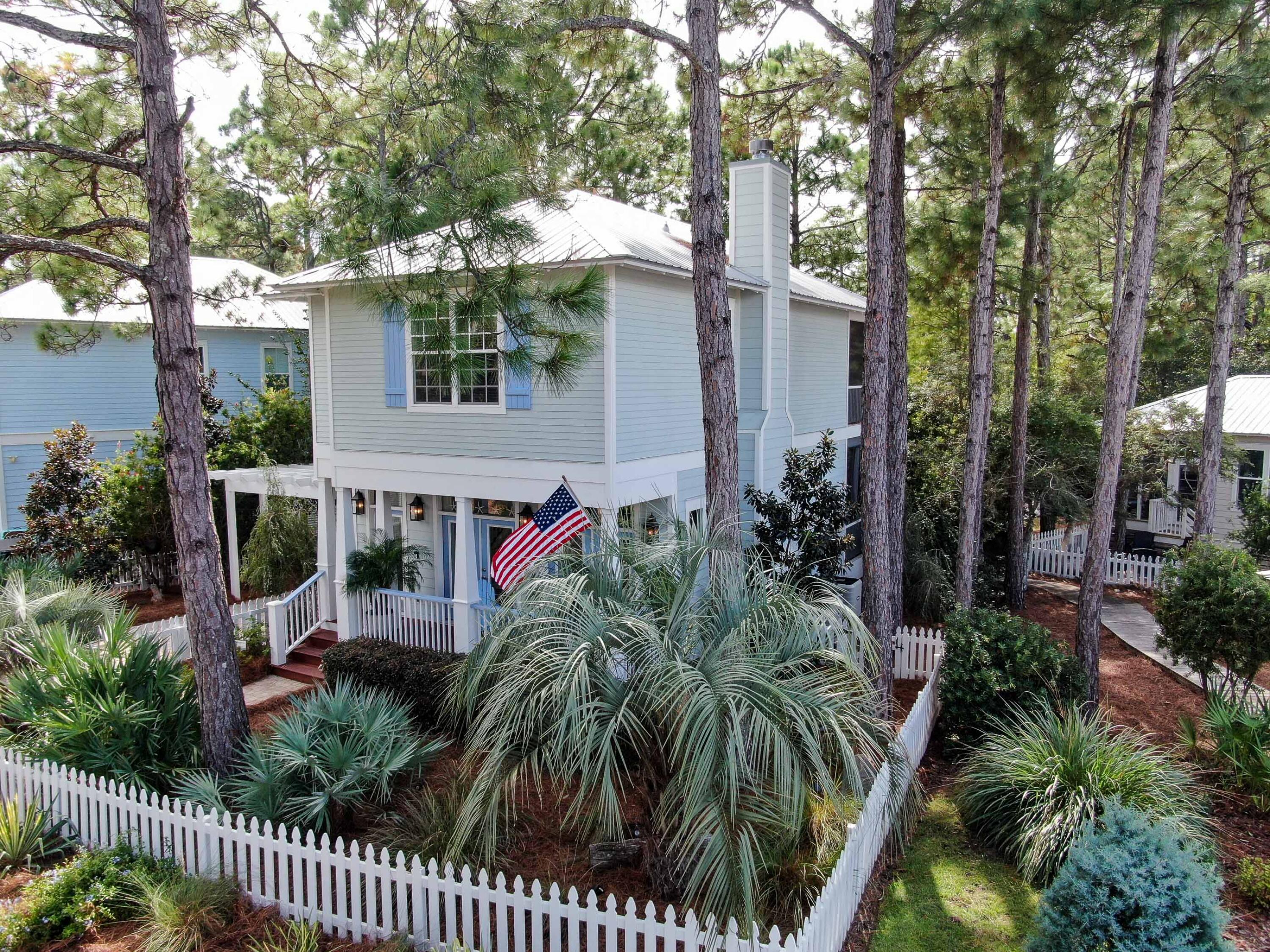 The epitome of 30A coastal chic awaits you in Cassine Village, a tranquil, hidden gem in the heart of Seagrove Beach. This custom home sits on one of the best lots in the community. Surrounded by lush landscaping and overlooking the pond, this private oasis just steps away from the community pool.  The large front porch welcomes you into an open floor plan perfect for entertaining. Thoughtful upgrades include 10' ceilings, hardwood floors, a gas fireplace, custom cabinetry, and designer fixtures. Enjoy indoor/outdoor living on one of the two oversized screened porches, and watch the squirrels run through the trees. The first floor also boasts a half bath, pantry, and laundry room. The second floor accommodates an oversized primary suite with a private bath, walk-in closet, and screened
