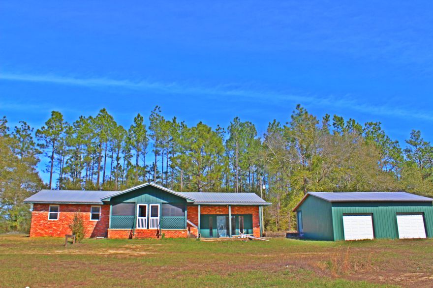 Welcome Home! This all brick home sits on 2 acres conveniently located South of I-10. This home features a screened in front porch, side patio & huge detached 30x25 2 car garage. The home sits back from the road to ensure privacy. A new metal roof was installed in 2007, along with new windows that flood this home with tons of natural light and tile throughout most of the home with new carpet in the bedrooms. A spacious living room flows into the eat-in kitchen and dining area which has had some upgrades and includes a walk-in pantry. The over-sized utility room with it's own sink attaches to a bathroom and bonus room. The 21x18 bonus room is unfinished and not included in the heated & cooled square feet, but has lots of potential and many possibilities.Home is being sold ''AS IS''.