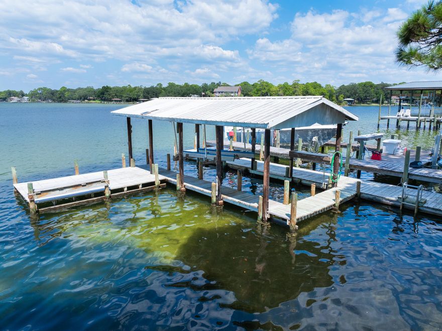 Enjoy peaceful waterfront living & convenience in the heart of Shalimar!  How about coffee in the Florida Room each morning overlooking a panoramic view of the tranquil cove?  Your boat is always on the lift and  ready at the dock for your short trip to the Choctawhatchee Bay! Highlights of this vintage gem include a Generac whole-house generator...original hardwood...sunny Florida Room...granite countertops...brand-new stainless-steel refrigerator...gas fireplace surrounded by ornate wooden mantel...crown moulding...hobby room area has great potential as office, additional bedroom or playroom...be sure to check out unique bathroom just off the garage in basement foyer...detached workshop (300sq') makes a great artist's shed or man cave!  Truly a must-see!