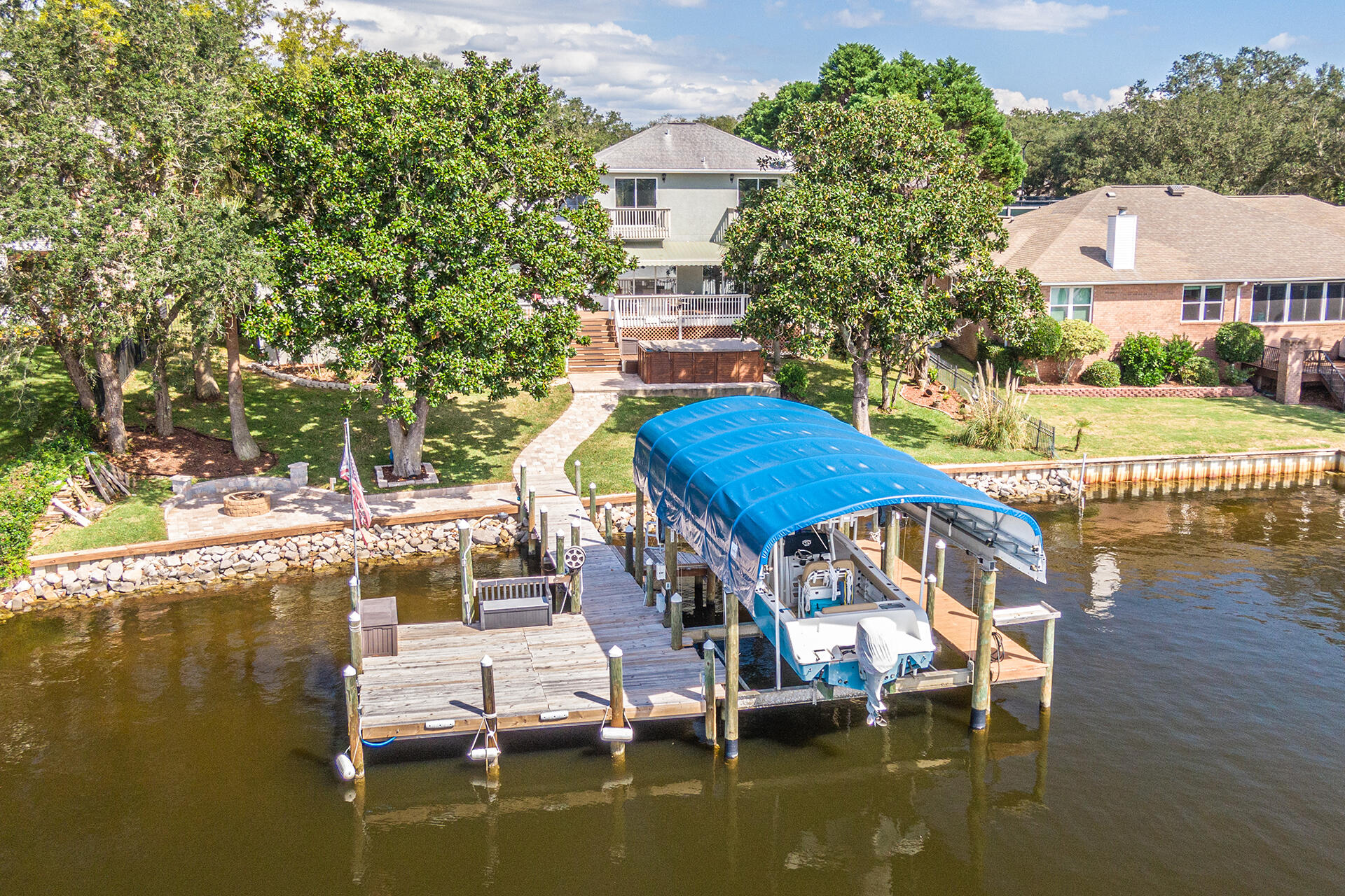 Enjoy WATERFRONT living at its finest- Private covered dock with boat lift and easy access to the bay. This beautiful home offers stunning lake views throughout! The living areas are perfect for entertaining; featuring tile floors, built-in bookcases, gas fireplace, and access to the large deck overlooking the water.Updated kitchen with stainless-steel appliance package, granite countertops, and white cabinetry. Spacious first floor primary bedroom with deck access and a luxurious en-suite bathroom featuring a double vanity, granite countertops, whirlpool tub, separate shower, and walk-in closet. There is one additional bedroom located downstairs, and two upstairs each with a private balcony overlooking the water.NEW ROOF SCHEDULED FOR INSTALL; mid-November 2021.  This home