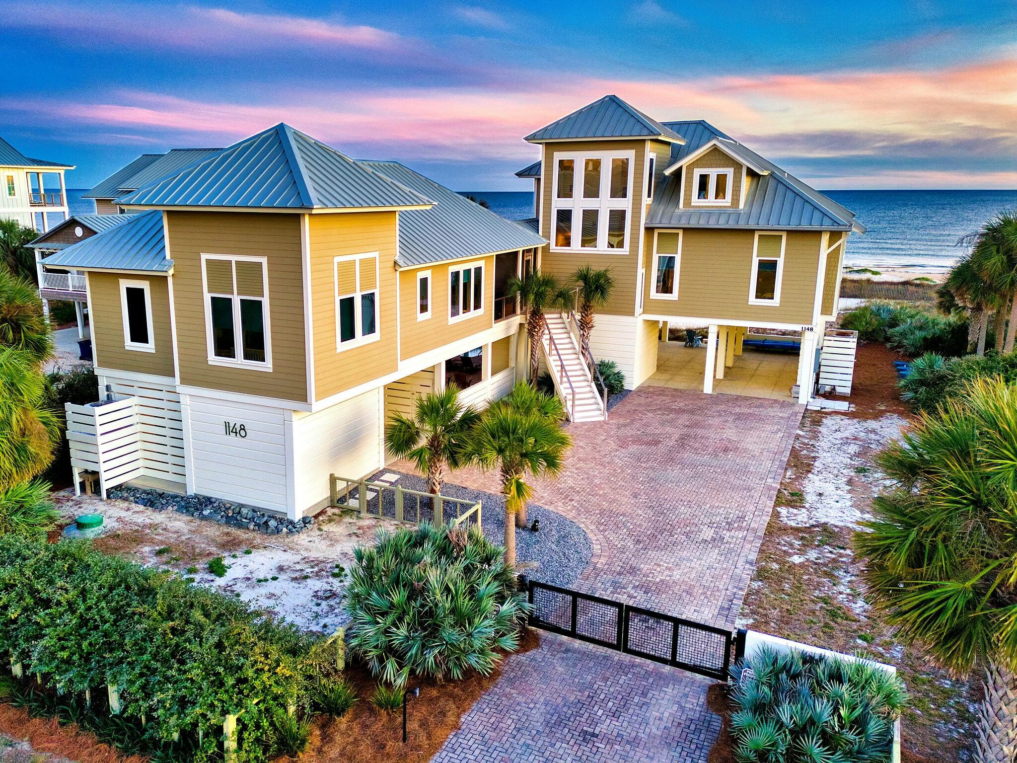 ''Ultimate Dream''. Upscale Gulf-Front home with Private Pool on St George Island's pristine East End. The gated brick driveway opens to a world of elegant coastal ambience graced with glorious sunrises and starlit skies. Strategically designed for multi-generational living, the 3 BR, 2 BA main home and 2 BR, 2 BA guest quarters connect via a convenient breezeway. The pentagonal shaped pool is surrounded by brick paved decking and expansive entertaining areas. Step inside the main home to a dramatic two-story atrium/living area suffused with natural light and featuring a coquina wall with gas fireplace. The 2nd floor master suite with private beachfront deck tastefully melds modern with intimate, merging the majesty of the ocean with interior tranquility.