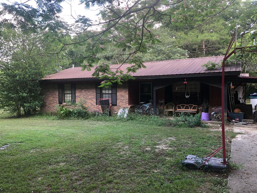 Calling all investors, where else can you find a 3 bedroom 2 full bath, fully brick home on an acre of land for under 140k. This home has a huge master bedroom.  Two additional bedrooms share a jack n jill bathroom.  Large kitchen with eat-in area.  Home needs some minor repairs. Metal roof installed about 5 years ago. Outside, there is a large flat backyard with beautiful mature trees, two outbuildings and an additional guest quarters with electricity,  full bath, a/c, and gas hot water heater. This property has so much potential.  Schedule your appointment today to see.