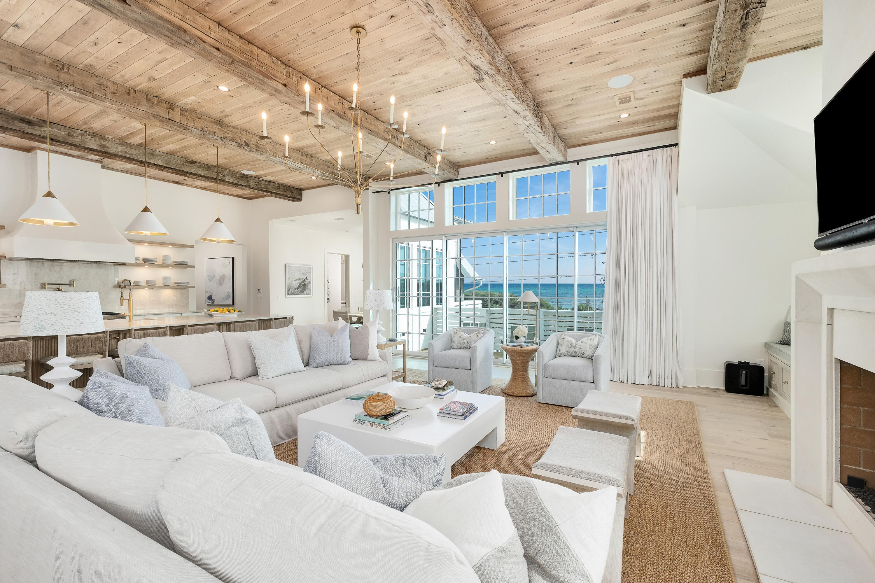 Nestled in the heart of Old Seagrove Beach, this remarkable beachfront residence effortlessly blends coastal Cape Cod elegance with a warm, welcoming ambiance. Meticulously designed by R.W. Lowe Architecture and Jenn James Designs, it offers a truly exceptional beach retreat. From the lagoon pool with its captivating gulf views to the practicality of an oversized garage and rear-access parking on Birmingham Street, every detail has been thoughtfully considered. This new construction home is meant for gathering with family and friends, featuring eight bedrooms, including three primary suites, and eight full baths with two half baths. Accessibility is a priority with a private elevator serving all levels. The upper levels boast stunning white oak ceilings adorned with reclaimed beams and light oak flooring. On the main level, durable shell stone tile seamlessly extends to the outdoor living area and pool deck, complete with a summer kitchen and direct access to Montgomery Street beach. Additional surprises await on the first level, including a secondary living room, game room, laundry room, and a custom bunk room. The well-planned second level offers multiple guest suites, six bedrooms, a spacious central living area, and an extra laundry room. The third level is the jewel in the crown, with a chef's kitchen and a central living room perfectly situated to capture the gulf's breathtaking views. The oversized dining area features custom touches and luxurious Taj Mahal countertops. The primary suite on this level is a sanctuary with private terraces for gulf gazing and a spa-like ensuite bath. Ascend to the rooftop deck for panoramic gulf views and unforgettable sunsets. Located on Scenic Highway 30A, this home offers access to the gulf's white sand beaches and the world-class shopping, dining, and local entertainment that 30A is renowned for. Elegant yet inviting, this coastal haven awaits those seeking a perfect blend of luxury and comfort.