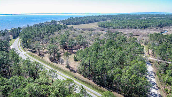 Private, already cleared lot with large oaks trees equaling .75 acres. Quiet neighborhood, no HOA which means no restrictions. Great investment and has city water and sewer available. Property fronts Bay Loop E but has a back road easement way in to property for pull through into lots. Mobile homes allowed.