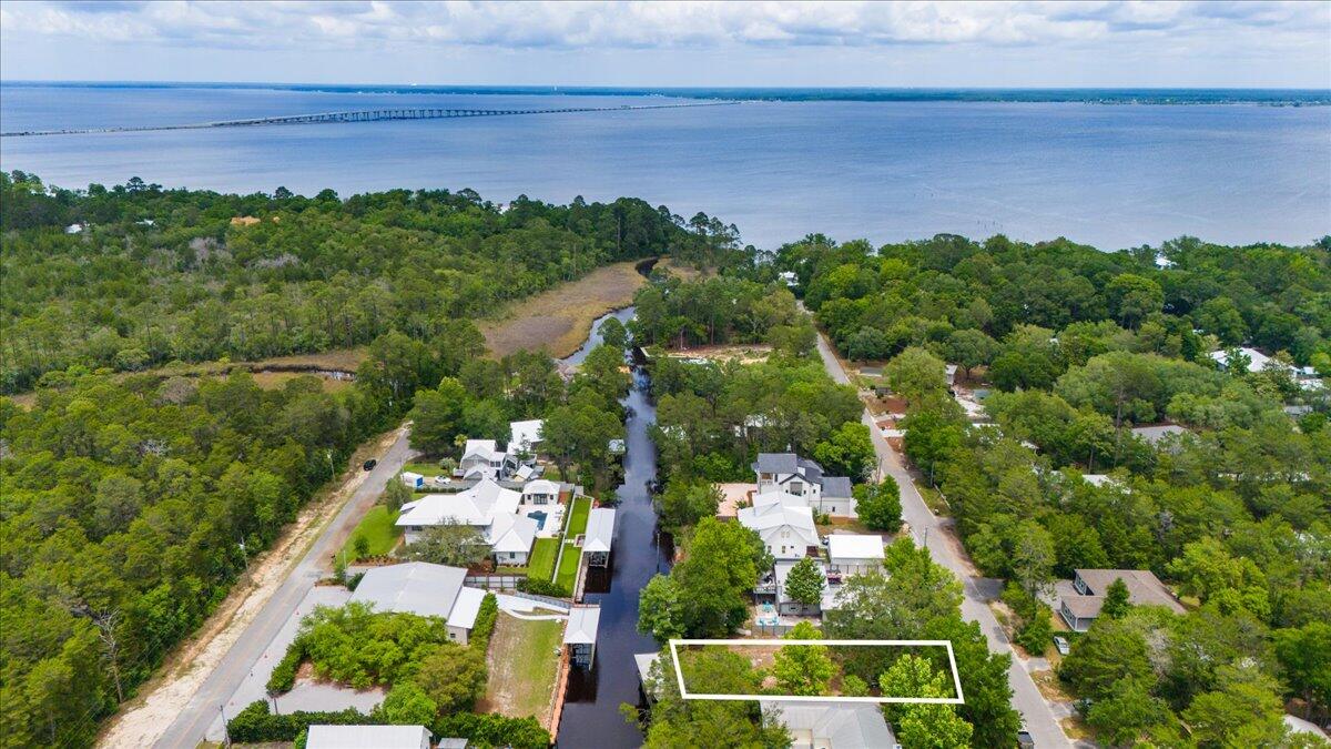 Serene deep water canal lot with magnificent oak tree. Boat dock with lift and partial fenced lot. Fully cleared and ready to build your waterfront sanctuary.