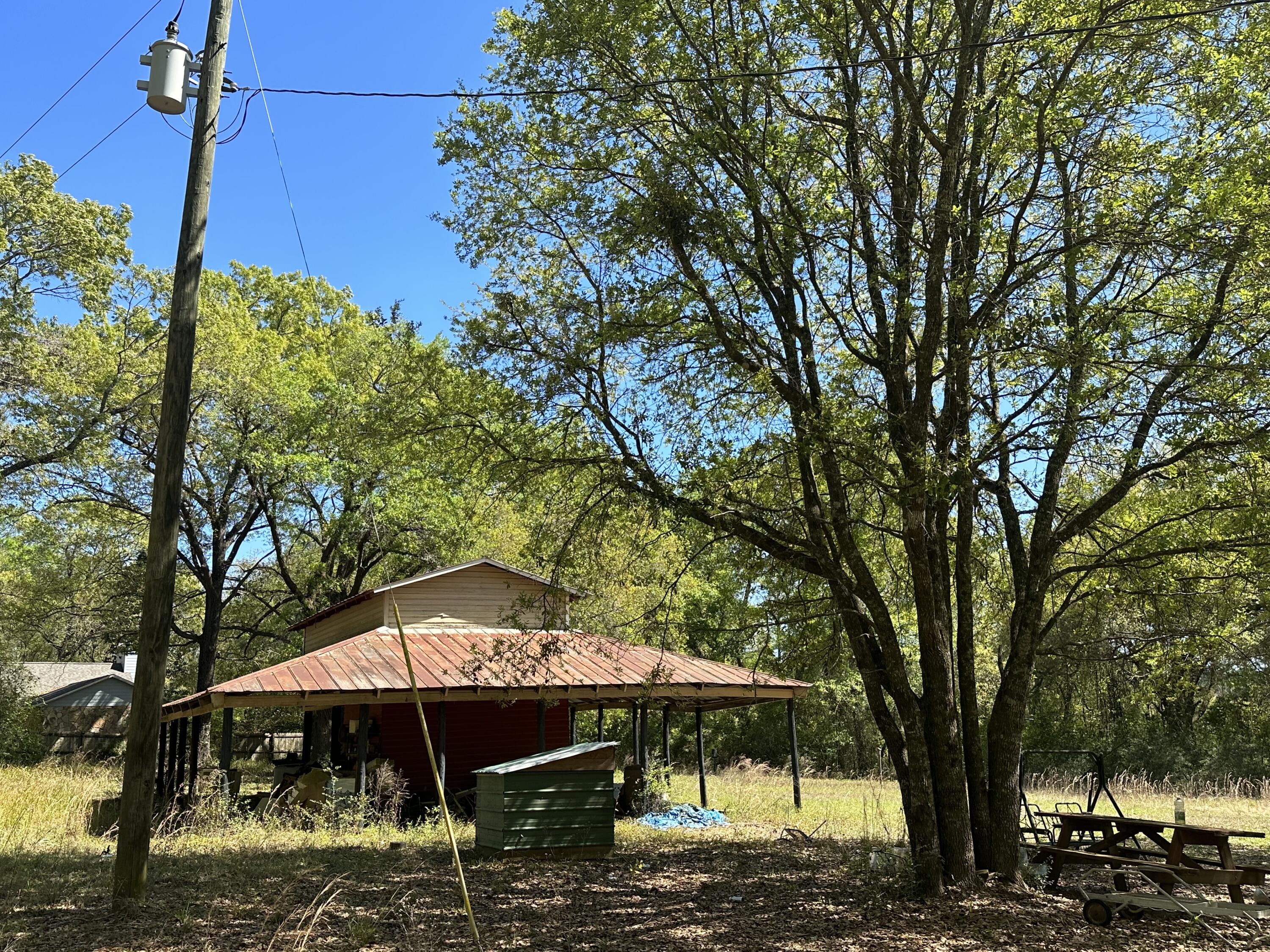 Barn/smokehose/Well/ power/ septic!! This incredible piece of 3.5 +/- Acres of Homesite is an opportunity not to be missed! With breathtaking views of the surrounding fields and unforgettable sunsets, you'll be able to bask in the beauty of nature every day. The massive oaks on the property add to the charm and character of the land. The RV hookups, septic, and well are already in place, and Baker water is available, so you can start building right away. The location is unbeatable too, with easy access to Hwy 90 and a short drive to local beaches, entertainment, shopping centers, military bases, and more. Don't wait, bring your build plans today and make this land your own!