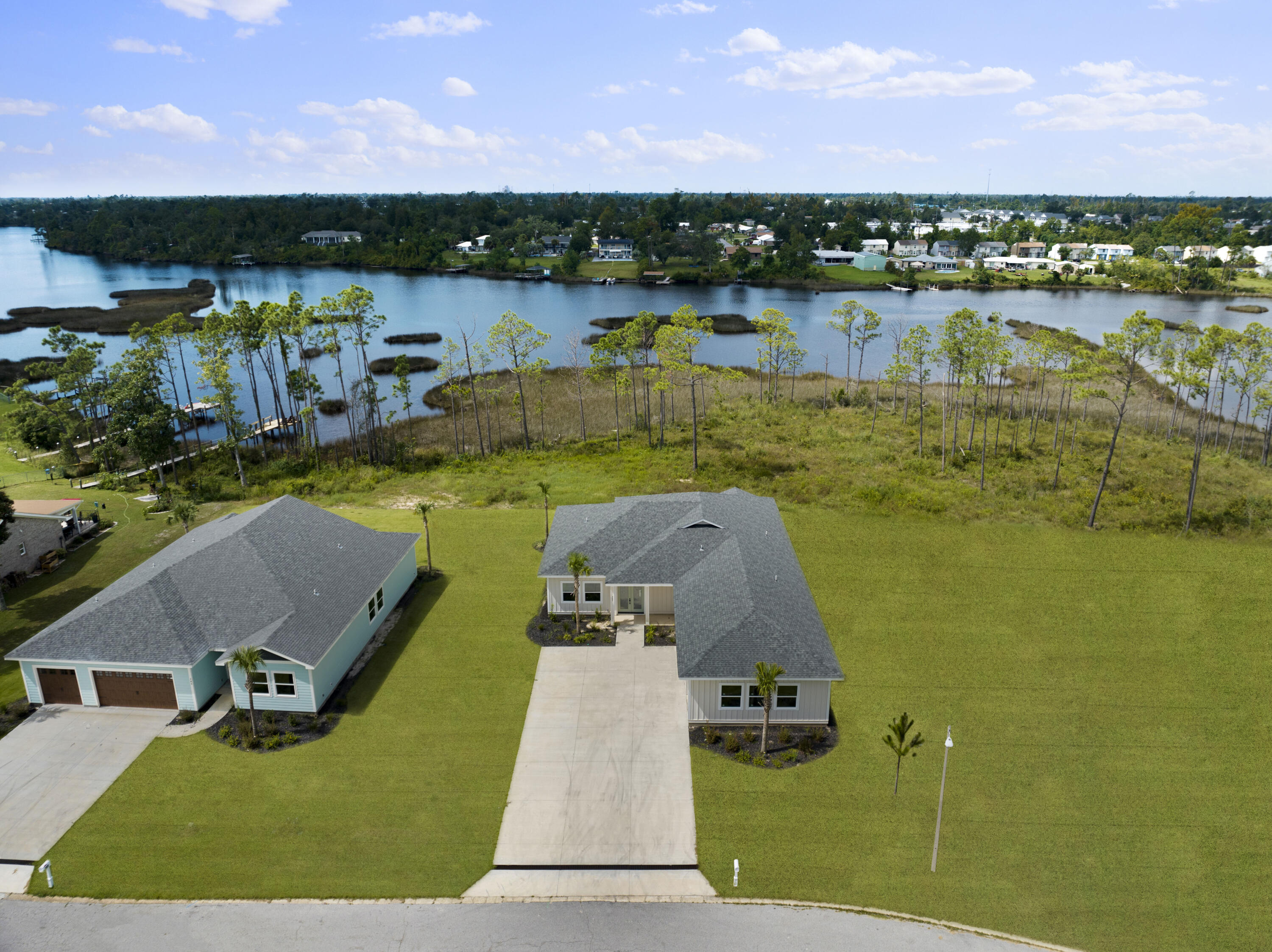 Discover your dream home located on Calloway Bayou just miles from the charm of Historic St. Andrews and downtown Panama City known for its quaint shops, dining & entertainment. This beautifully crafted NEW construction waterfront property, offering the perfect blend of modern living and tranquil waterfront beauty on nearly a half acre lot. Imagine waking up to breathtaking water views & enjoying the convenience of adding your own private dock or luxurious pool to create the ultimate outdoor oasis. Navigate Callaway Bayou all the way to East Bay and Shell Island. Enjoy true serenity and activities like fishing, paddling, kayaking & boating right from home. Don't miss this rare opportunity to own a beautifully appointed home in paradise with NO HOA! Prime location near Tyndall AFB Interior offers beautiful architectural details like tongue and groove pine vaulted ceilings, incredible pocket sliders bringing the outside in and upscale state of the art kitchen. Additional features are ensuite bathrooms for every room, stainless appliances, Quartz countertops, an open floor plan ideal for entertaining and premier indoor/outdoor living with an expansive covered back porch. The lot is large enough for a pool and you can add a dock for easy access to the water. Not one but two bedrooms are waterfront and you can capture the same stunning views from the living & dining area and kitchen. The main living areas and primary bedroom features luxury vinyl flooring. The ensuite bathrooms are impressive with custom tiled showers and the primary also offers a large soaking tub to unwind in. There is a half bath off the kitchen which is ideal while entertaining. There is nice storage with the 3-car garage and plenty of parking. Don't miss out on this amazing opportunity to own an exceptional waterfront new construction home and the chance to embrace the ultimate coastal lifestyle.