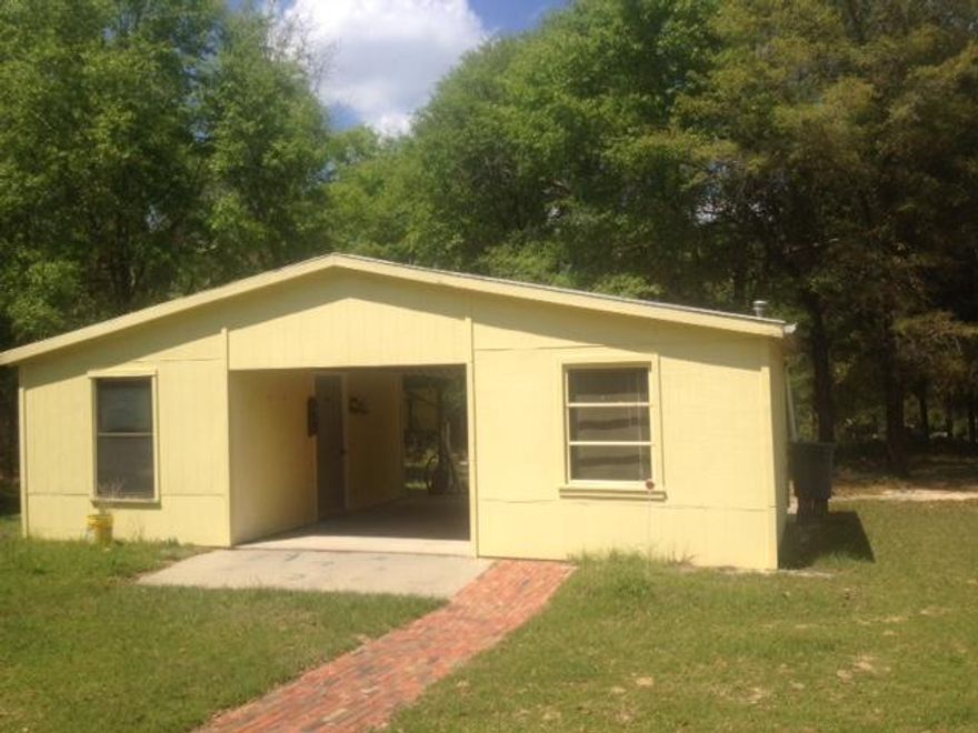 PRICED TO SELL! GREAT LOCATION! This beautiful home has been very well kept. The sellers placed a roof over, over this home when it was originally set up new. It comes with a beautiful 1.66 acres and a very nice workshop with storage. The front entrance features a large covered concrete porch and a large screened in porch on the back of the home. The beautiful landscaping is also in place including an area ready to plant your garden. The home itself is 3 bedrooms 2 baths and features a large soaker tub in the master. The kitchen comes complete with a refrigerator. The home is being sold ''as is'' and sellers will not accept financing contingencies due to age of the home. However, it is in great condition and is move in ready! Call for your tour today! It won't last long!