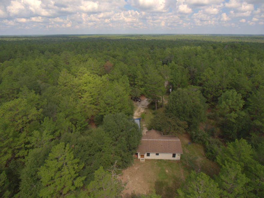 Wonderful, smaller home tucked away in the woods. 4.77 acres of lush forest and walking trails. This great get away has so much to offer with a long treed driveway, a separate RV pad with power, a ''man-cave'' workshop and great privacy for outside activities and relaxing. Inside the home you will find 2 bedrooms in a split floor plan and a turn key, very neat and tidy home. The ceilings are textured and this home is extremely clean. Come and look the property and home over and make it your own. If you are considering a Florida cottage only 30 minutes to the military bases, the white beaches and shopping along the Emerald coast, this may be just the place you are looking for.