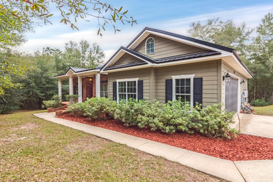 Quiet secluded living in the heart of town! This home features 4 bedrooms and 3 full baths in nearly 2000 beautiful square feet. New paint throughout. Gorgeous laminate, granite countertops, beautiful tile, cathedral ceilings, trayed ceilings, beautiful fixtures, screened back porch...this home has it all! In addition to the 2 car garage, there is a fantastic 25x35 workshop/garage/building with electricity just waiting for your projects! Nearly 2 acres of privacy, yet near everything. Come see this one today!