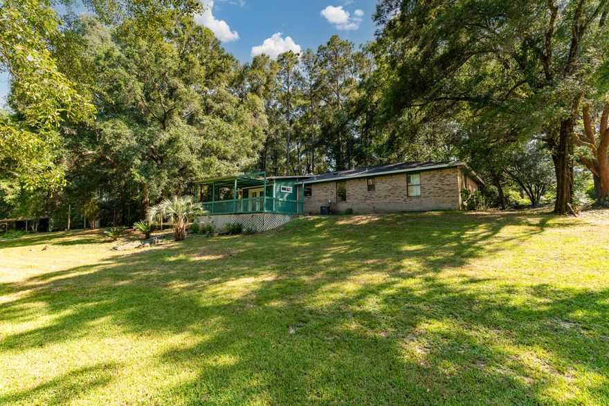 BACK ON THE MARKET - **NEW ROOF INSTALLED 2024** This tranquil 4-bedroom, 2-bath brick home, offers 2 acres of lush green lawn and custom-planted trees. It's a nature lover's paradise with a bonfire pit, covered deck, built-in outdoor koi pond, and Mill Creek access. It features an open floor plan, freshly painted interior, luxury Pergo flooring, and outside deck access through French doors. A spacious metal roof shed is placed perfectly on site. Don't miss your chance to own a rare 2-acre lot in the heart of Crestview. The major upgrades have already been completed for you. **HVAC system - 2022 & Water Heater - 2023, and NEW light switches.** Minutes from schools, shopping, and dining. With a few indoor repairs and TLC, this No HOA property can be transformed into your dream home